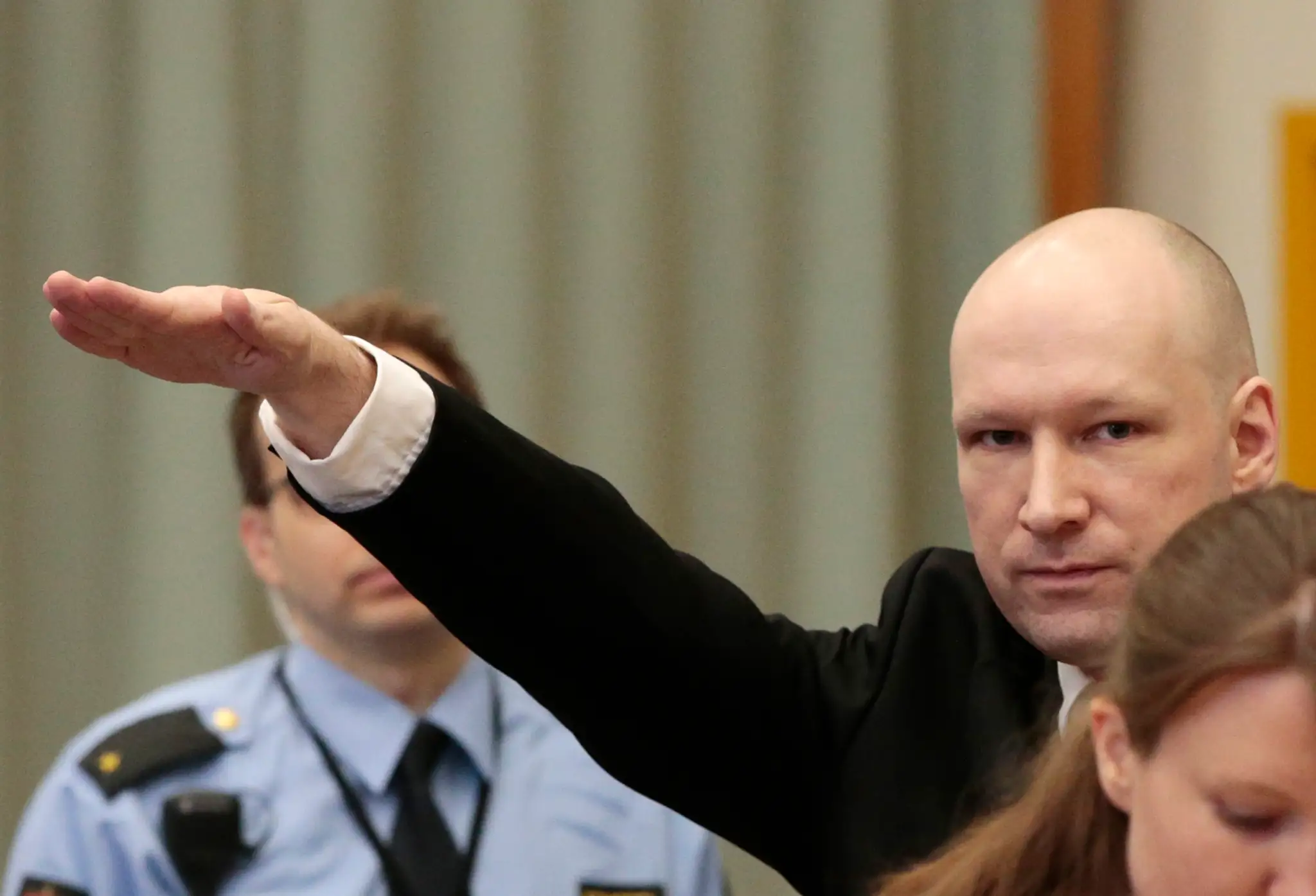 Anders Behring Breivik hajluje v súdnej sieni.
