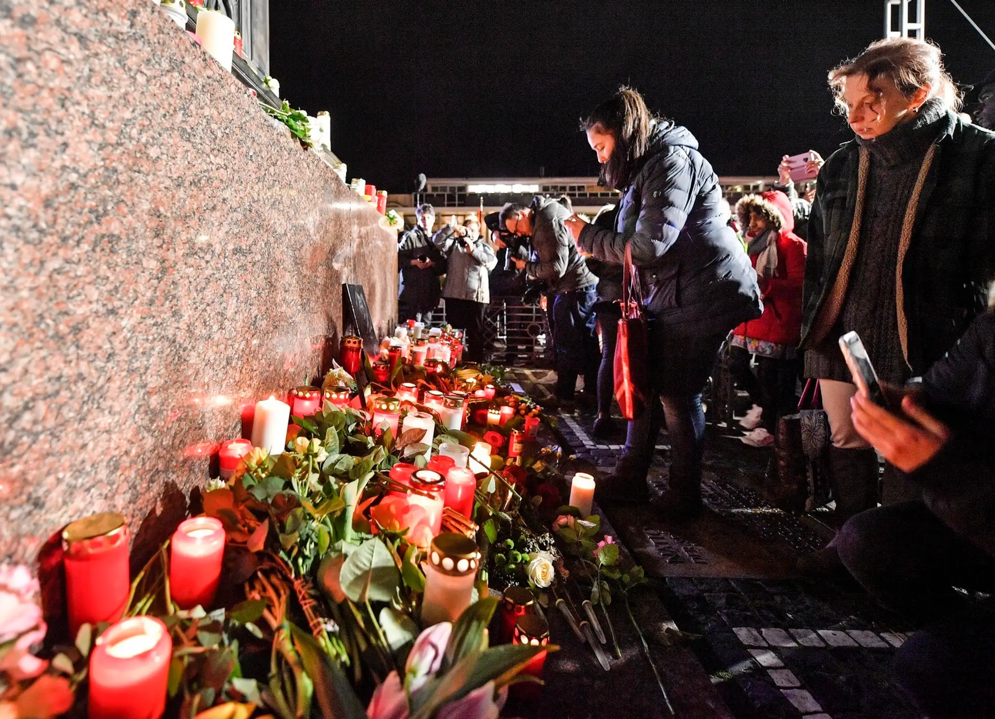 Žena drží sviečku v Mníchove počas spomienky na obete streľby v Hanau.