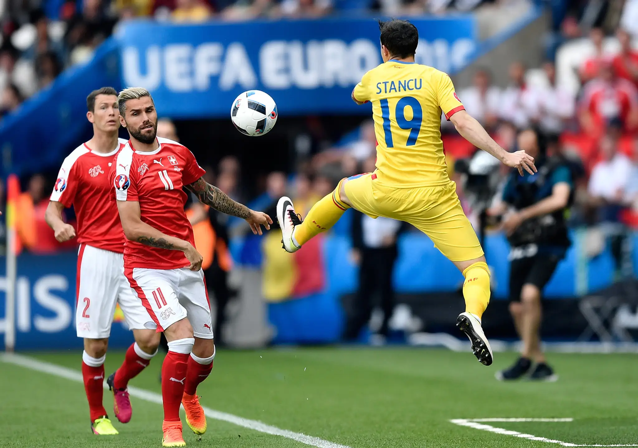 Rumun Bogdan Stancu (vpravo) a Švajčiar Valon Behrami bojujú o loptu na ME vo Francúzsku.