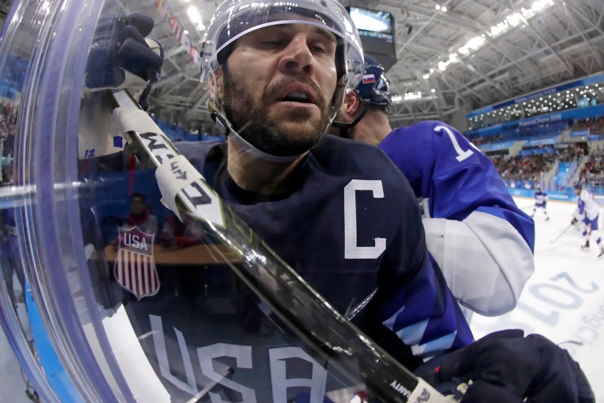 Kapitán USA Brian Gionta je narazený na mantinel Tomáš Starostom v osemfinále ZOH 2018.