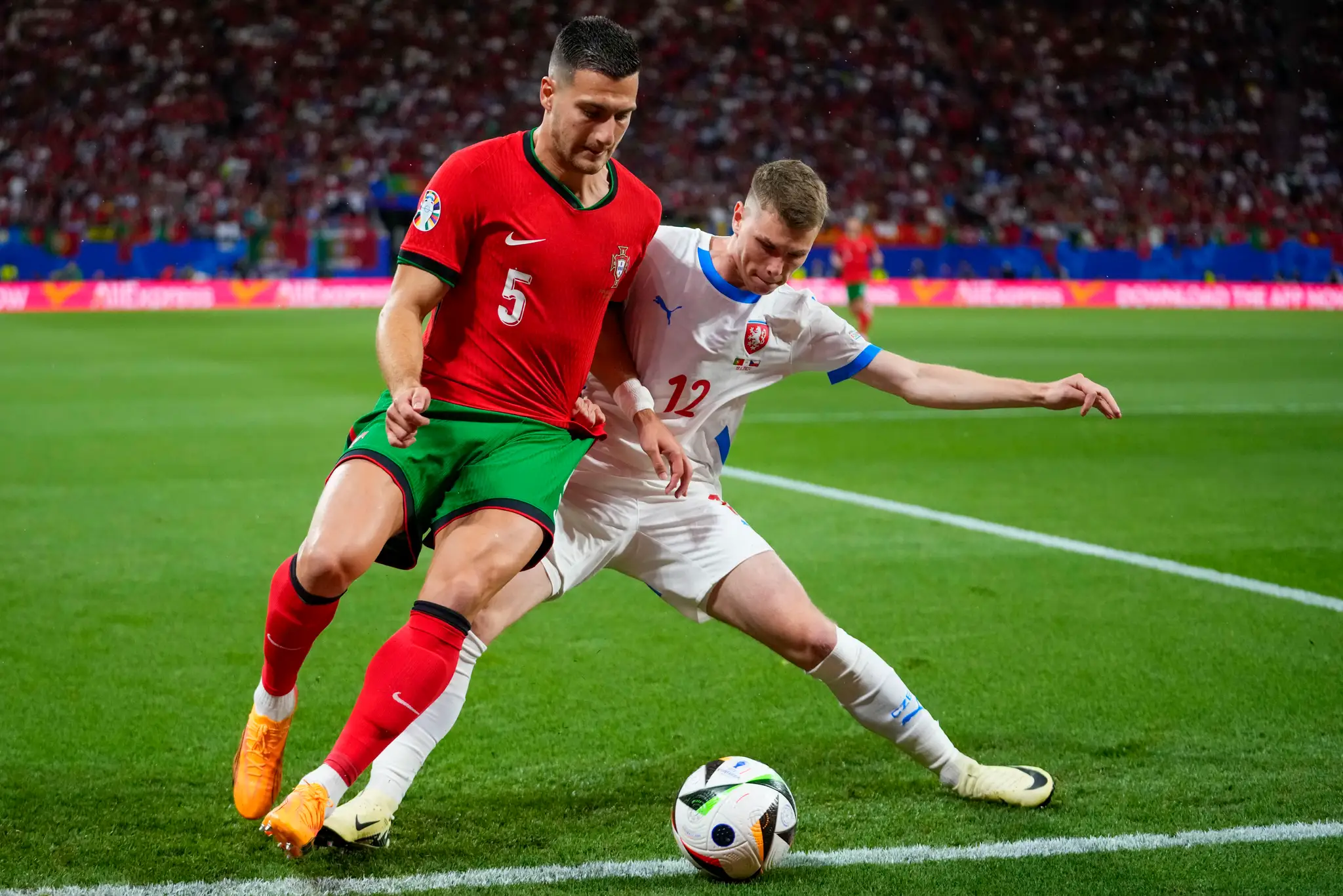 Portugalský hráč Diogo Dalot (vľavo) bojuje o loptu s Čechom Davidom Douderom.
