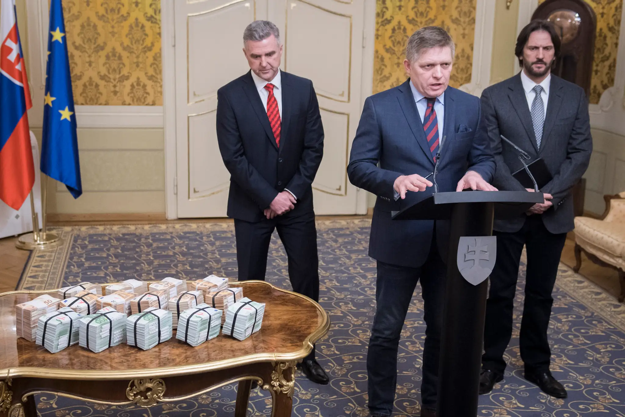 Na snímke vľavo dolu je na stolíku milión eur, ktoré premiér sľúbil za relevantné informácie v prípade dvojnásobnej vraždy