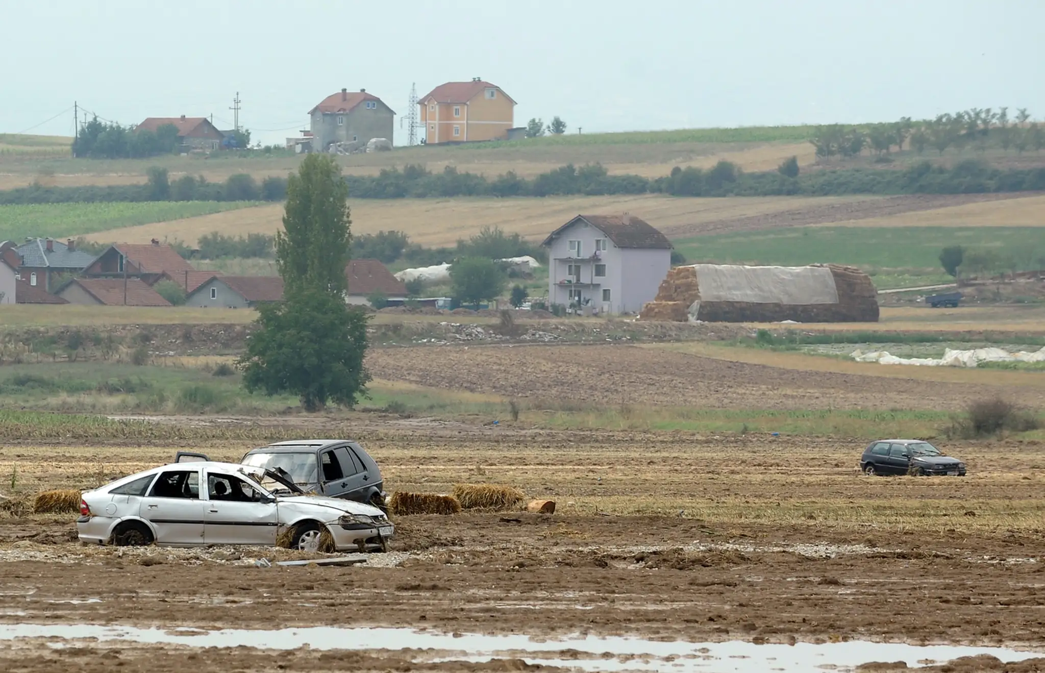 Veľká voda, ktora zaplavila macedónsku dedinu Stajkovci zo sebou strhla autá, ktoré vyplavila na poliach.