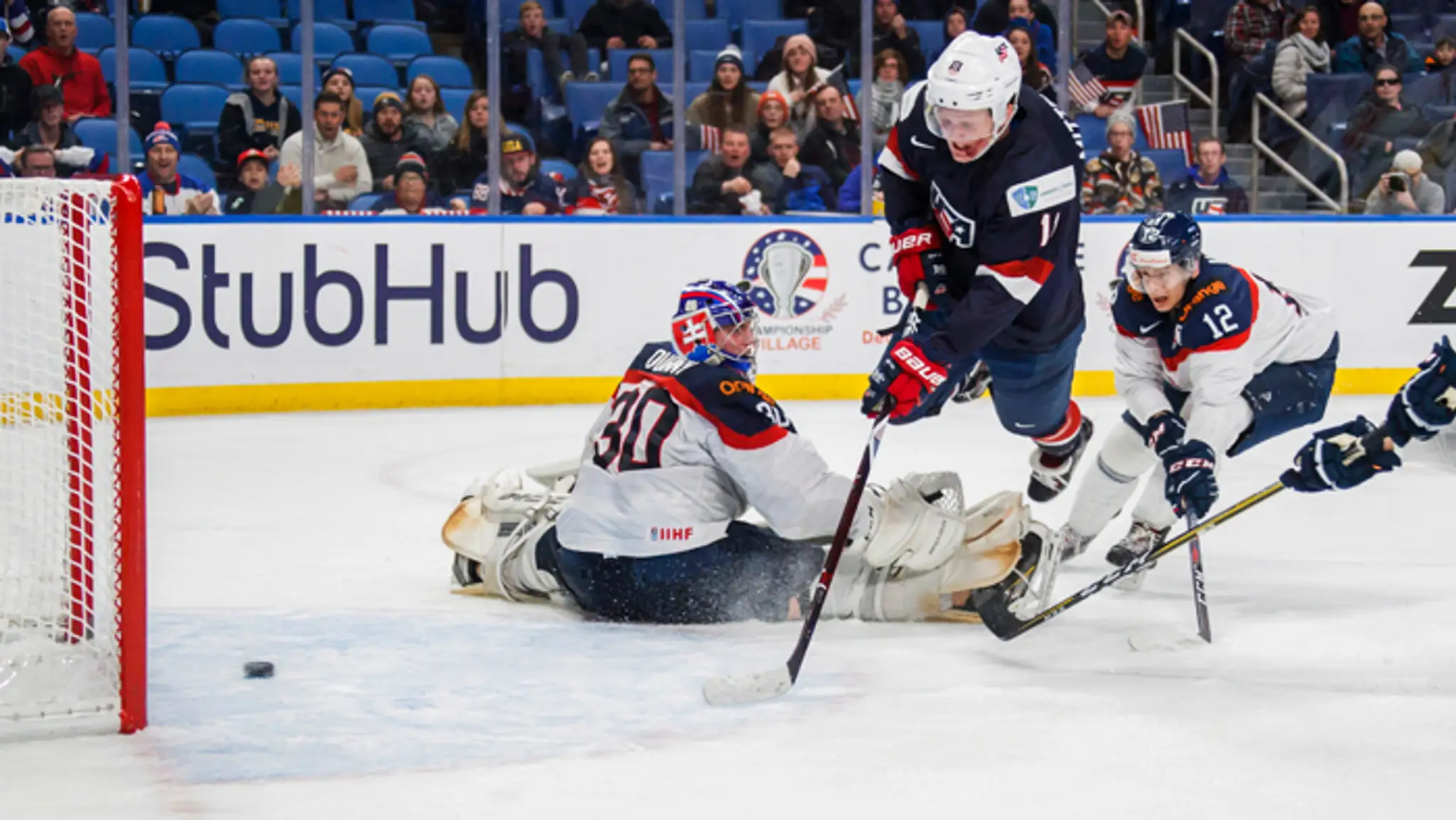Hráč USA Ryan Poehling v akcii s Vojtechom Zeleňákom a Filipom Krivošíkom.