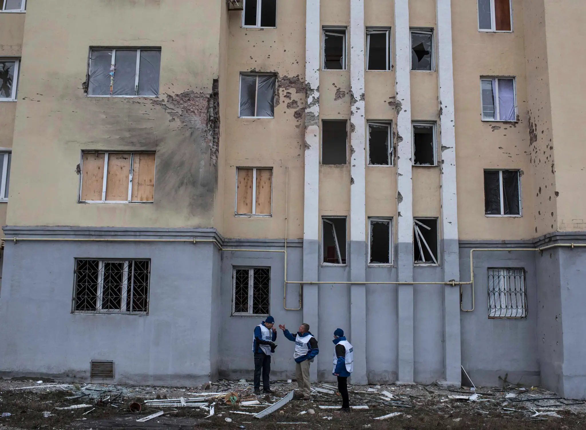 Príslušníci OBSE monitorujú vyšetrovanie pred poškodenou bytovkou po sobotňajšom raketovom útoku v obytnej štvrti vo východoukra