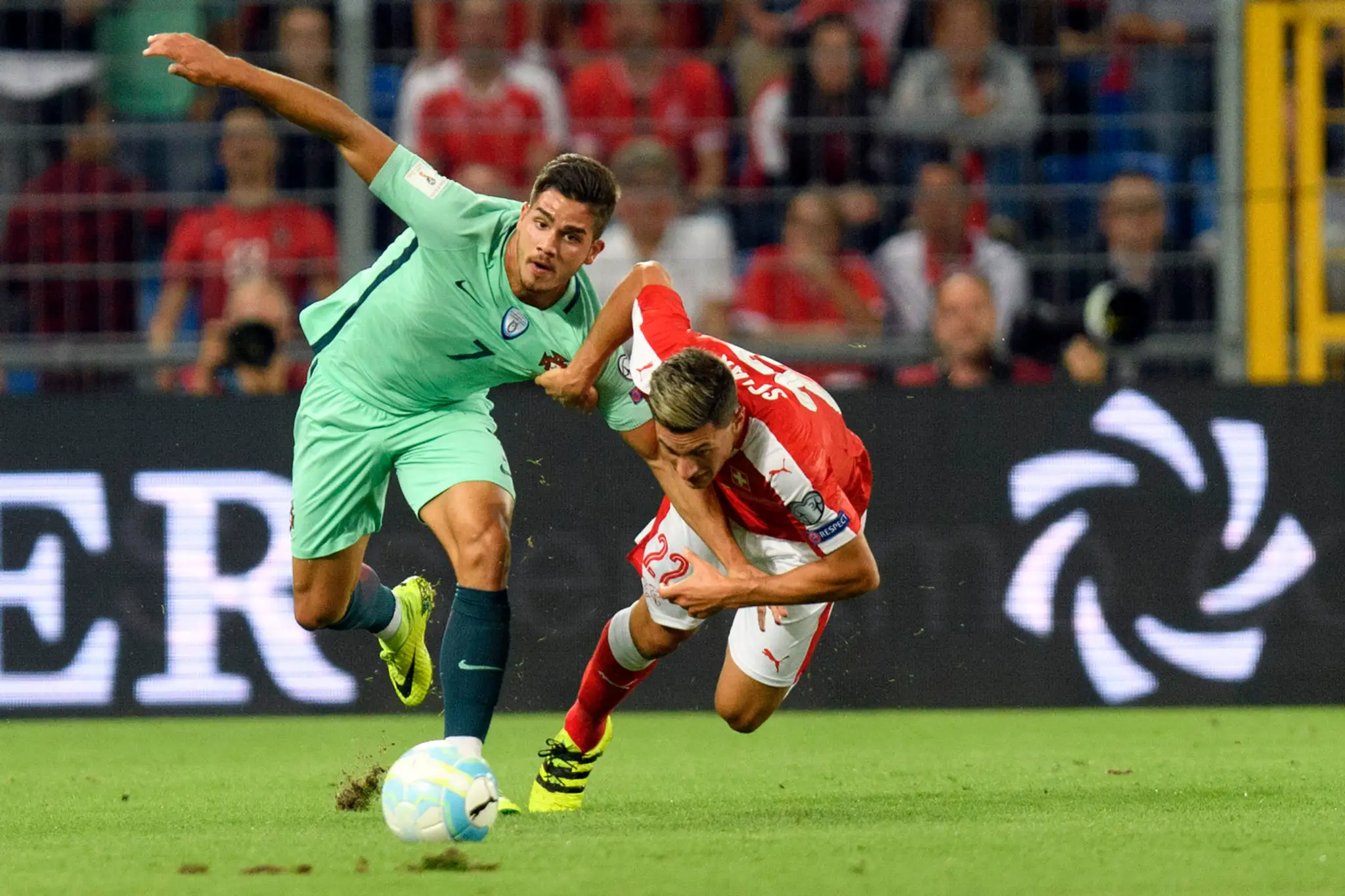 Portugalčan André Silva (vľavo) v dôraznom súboji so Švajčiarom Fabianom Schärom v kvalifikácii MS 2018.