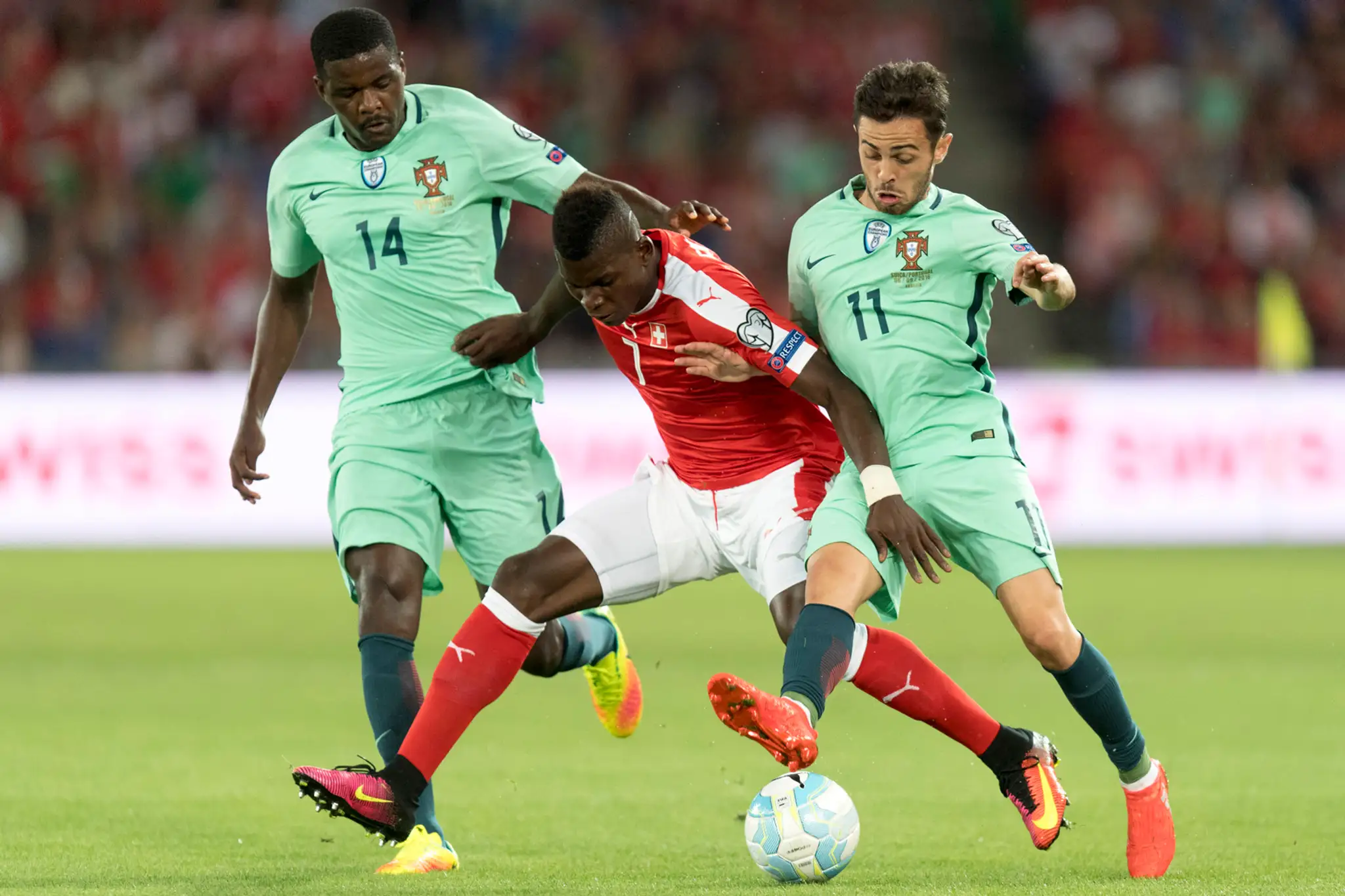 Veľká švajčiarska nádej Breel Embolo (v červenom) v súboji s dvomi Portugalčanmi - napravo Bernardom Silvom a Wiliamom Carvalhom