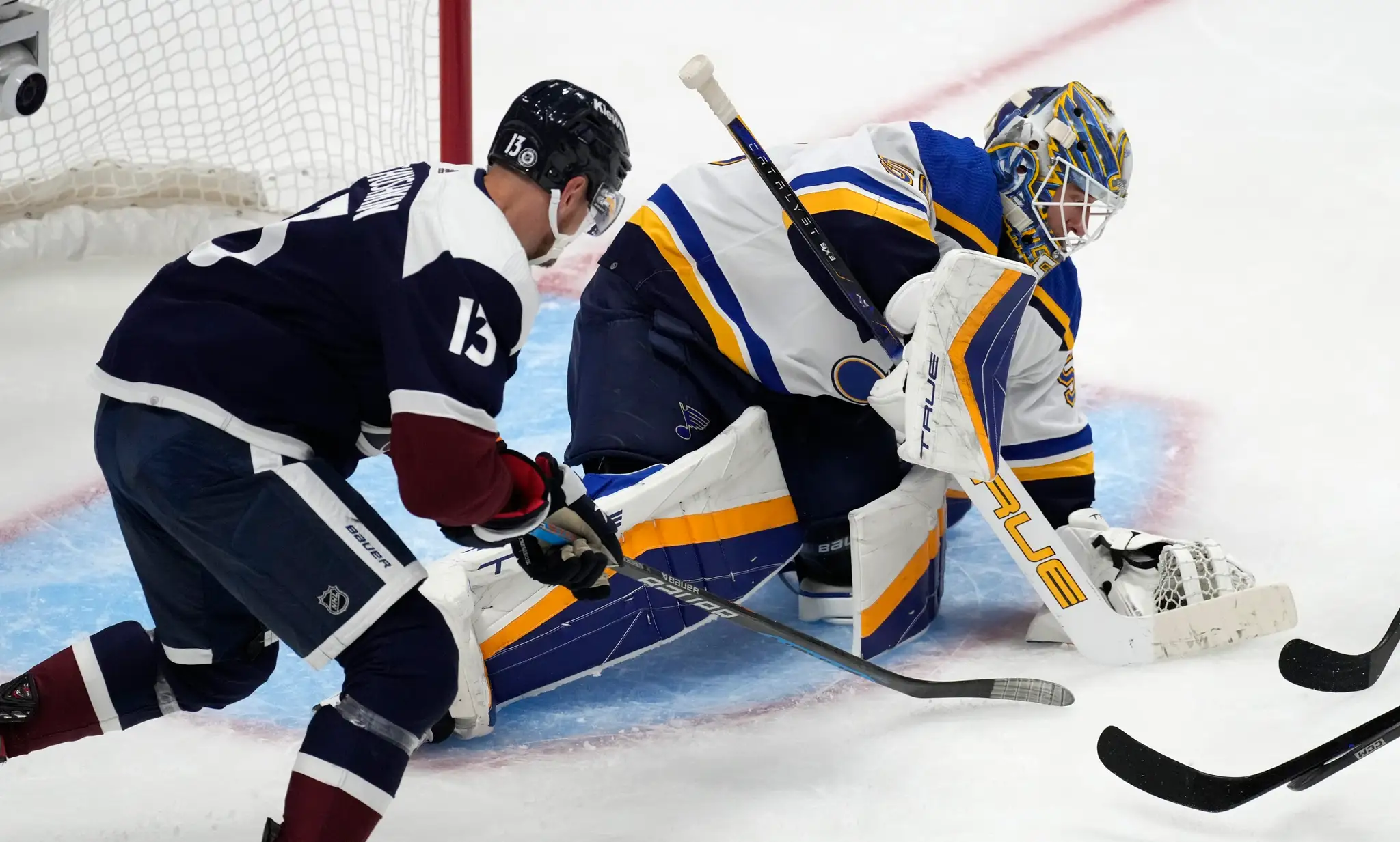 Brankár St. Louis Blues Jordan Binnington (vpravo) kryje puk po tom, čo zastavil strelu pravého krídla Colorada Avalanche Valeriho Nicushkina. 