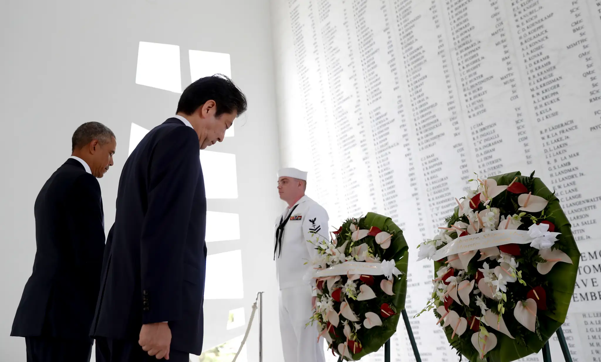 Japonský premiér Šinzó Abe a prezident USA Barack Obama sa skláňajú počas kladenia vencov pri pamätníku nad vrakom lodi Arizona.