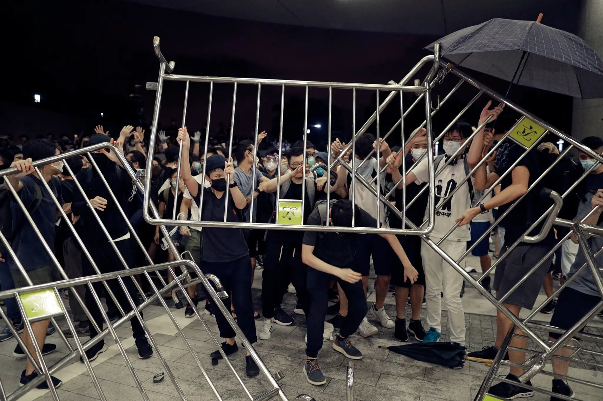 Policajti v Hongkongu zatýkajú protestujúceho muža.