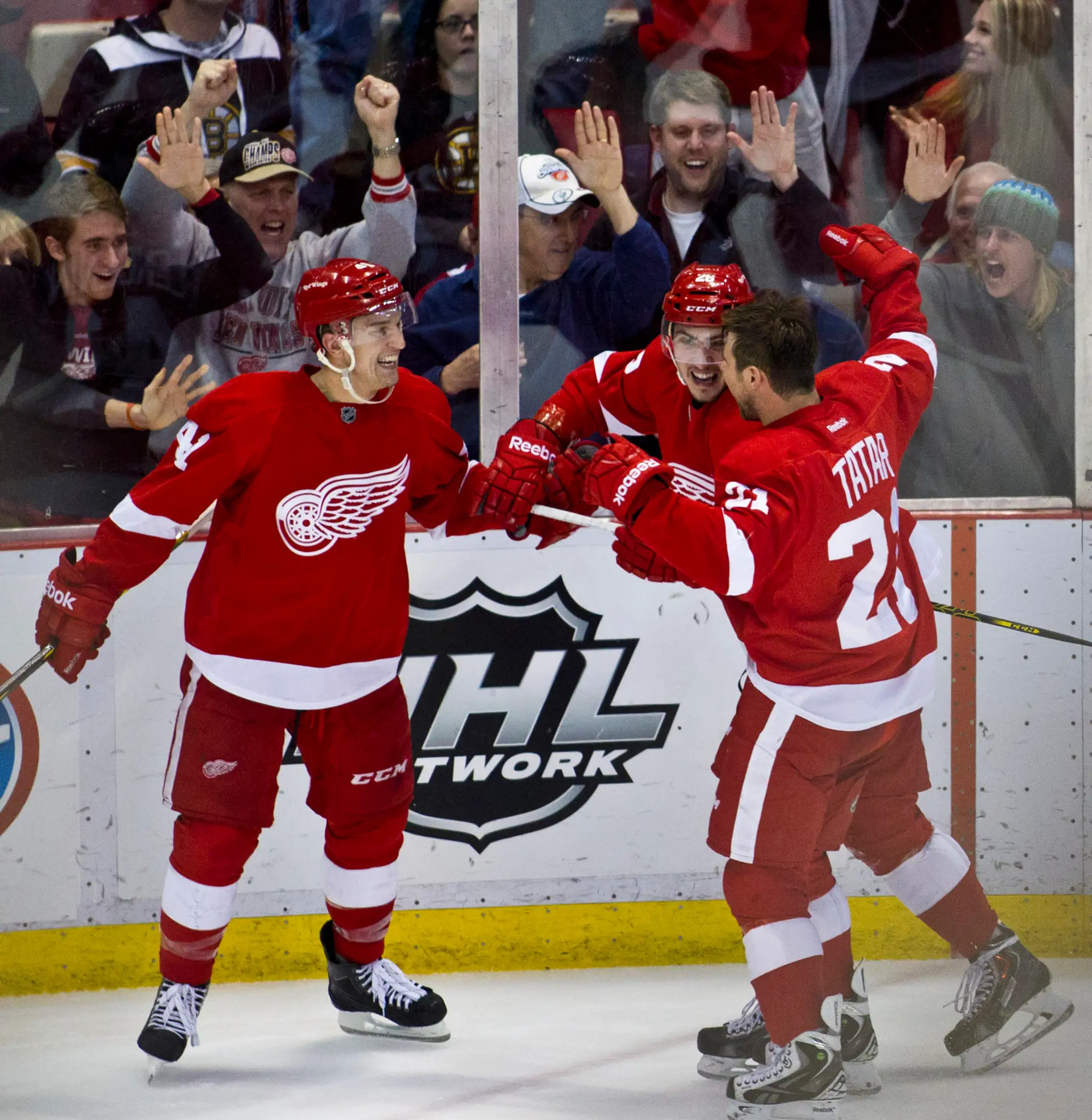 Hokejista Detroitu Red Wings Slovák Tomáš Jurčo (uprostred ) sa teší so svojím spoluhráčom a krajanom Tomášom Tatarom (vpravo)