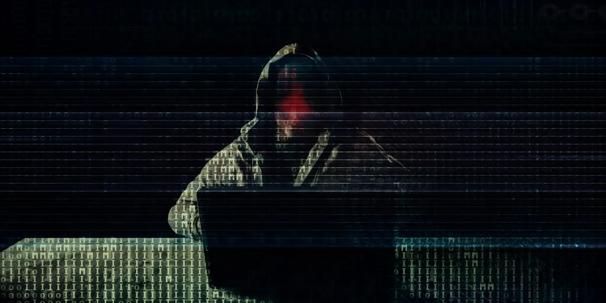 Na snímke hacker, ktorý sedí za počítačom.