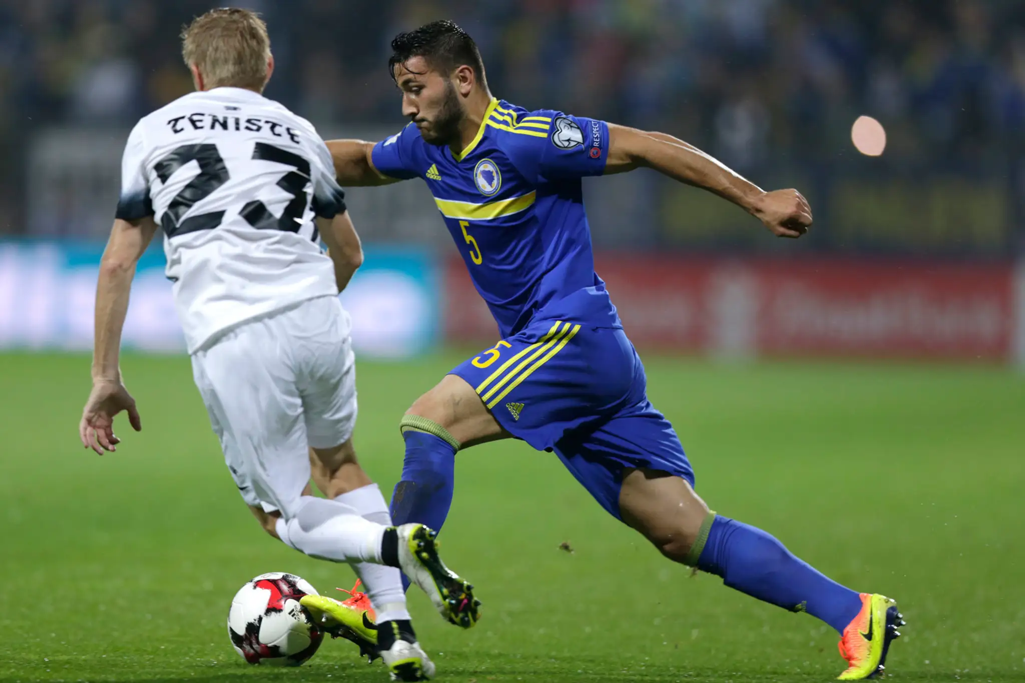 Bosniansky obranca Sead Kolašinac (vpravo) bojuje proti Estóncovi Taijovi Tenistemu v kvalifikačnom dueli MS 2018.