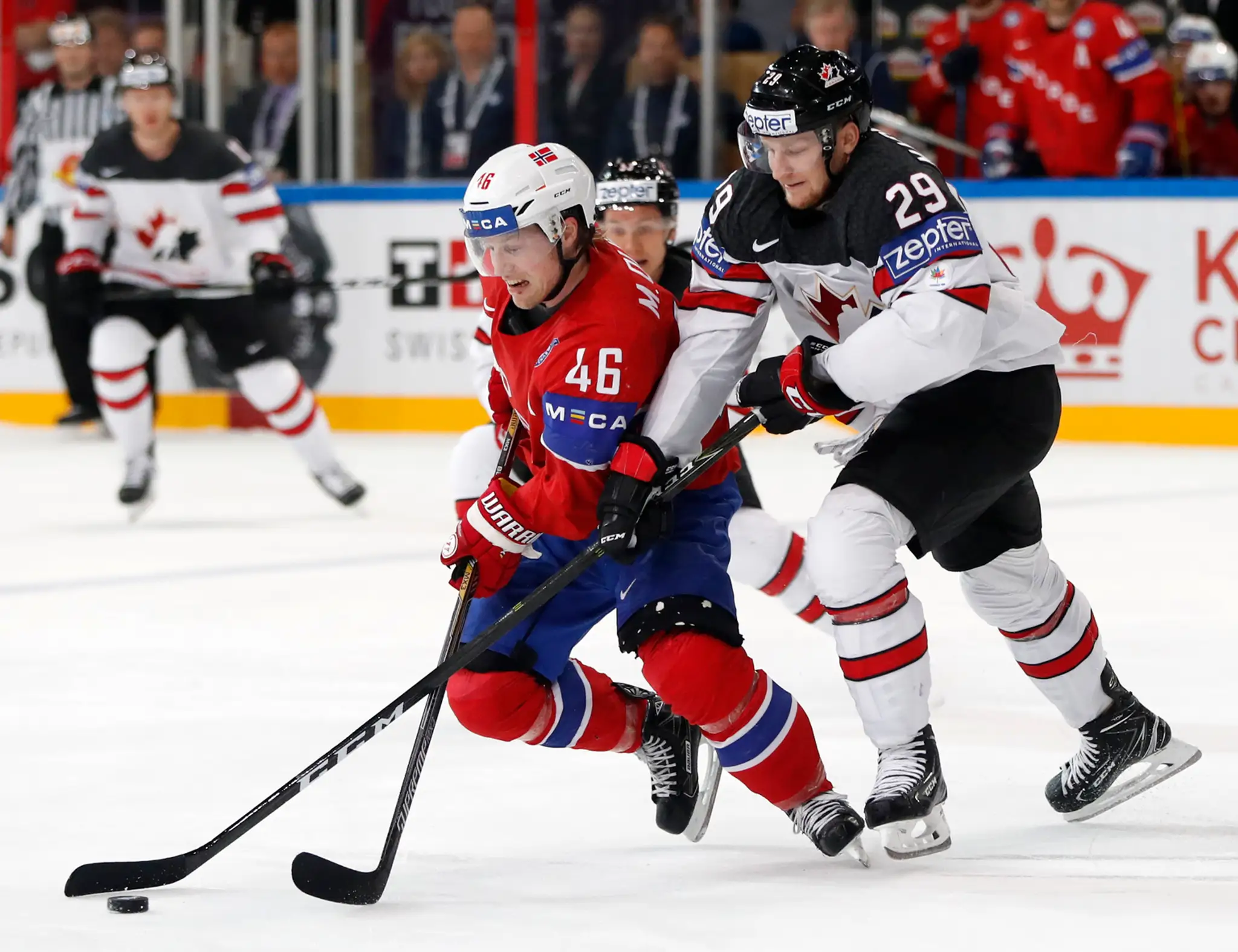 Nathan Mackinnon (vpravo) z Kanady útočí na Nóra Mathisa Olimba v zápase MS 2017.