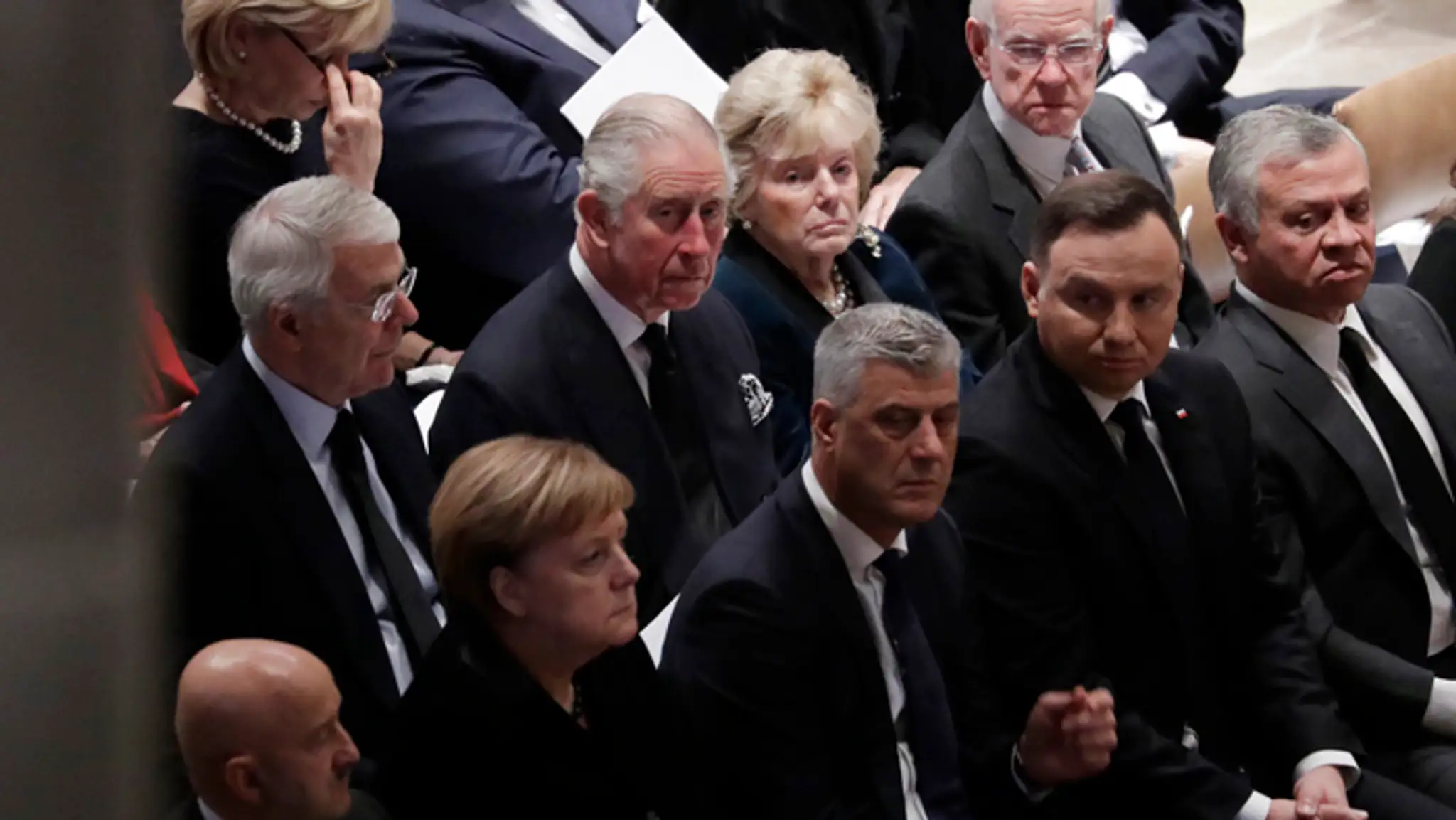 Princ Charles, britský expremiér John Major a nemecká kancelárka Angela Merkelová na pohrebe Georgea Busha.