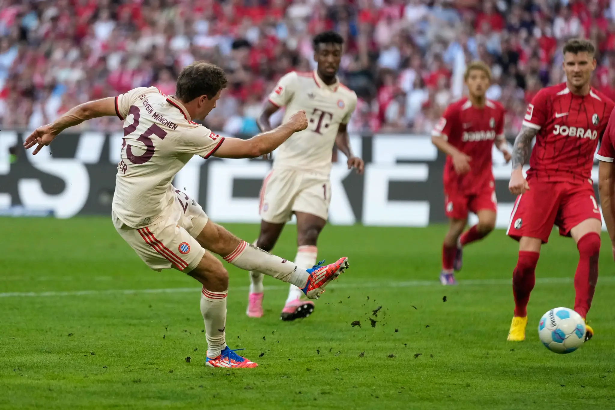 Futbalista Thomas Müller (vľavo) strieľa gól