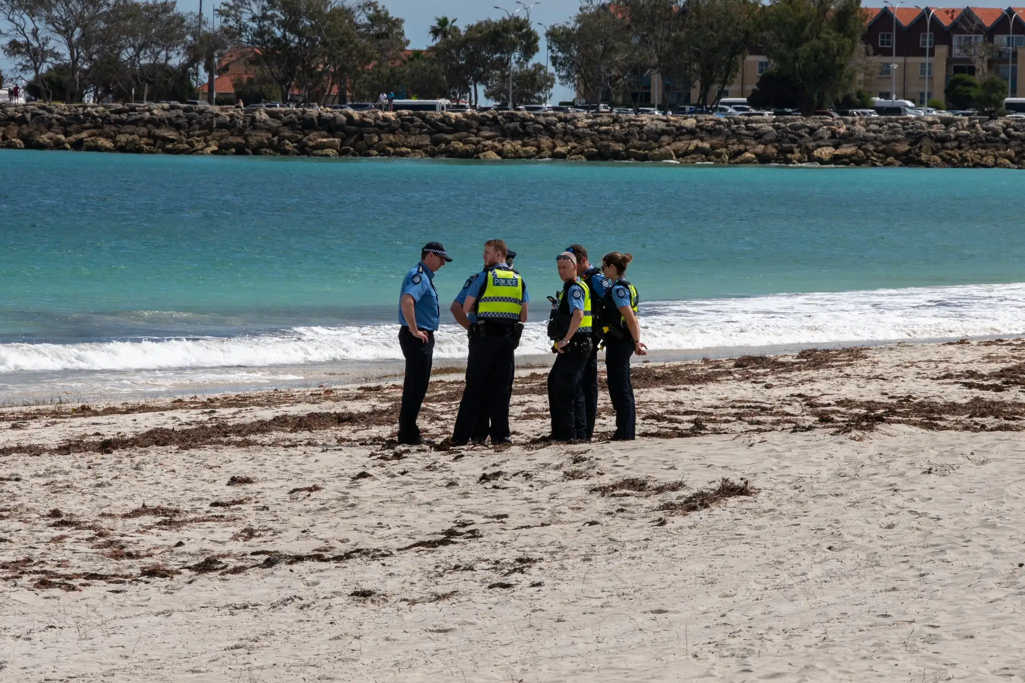 Policajti stoja na pláži Sorrento Beach  po útoku žraloka v austrálskom Perthe.
