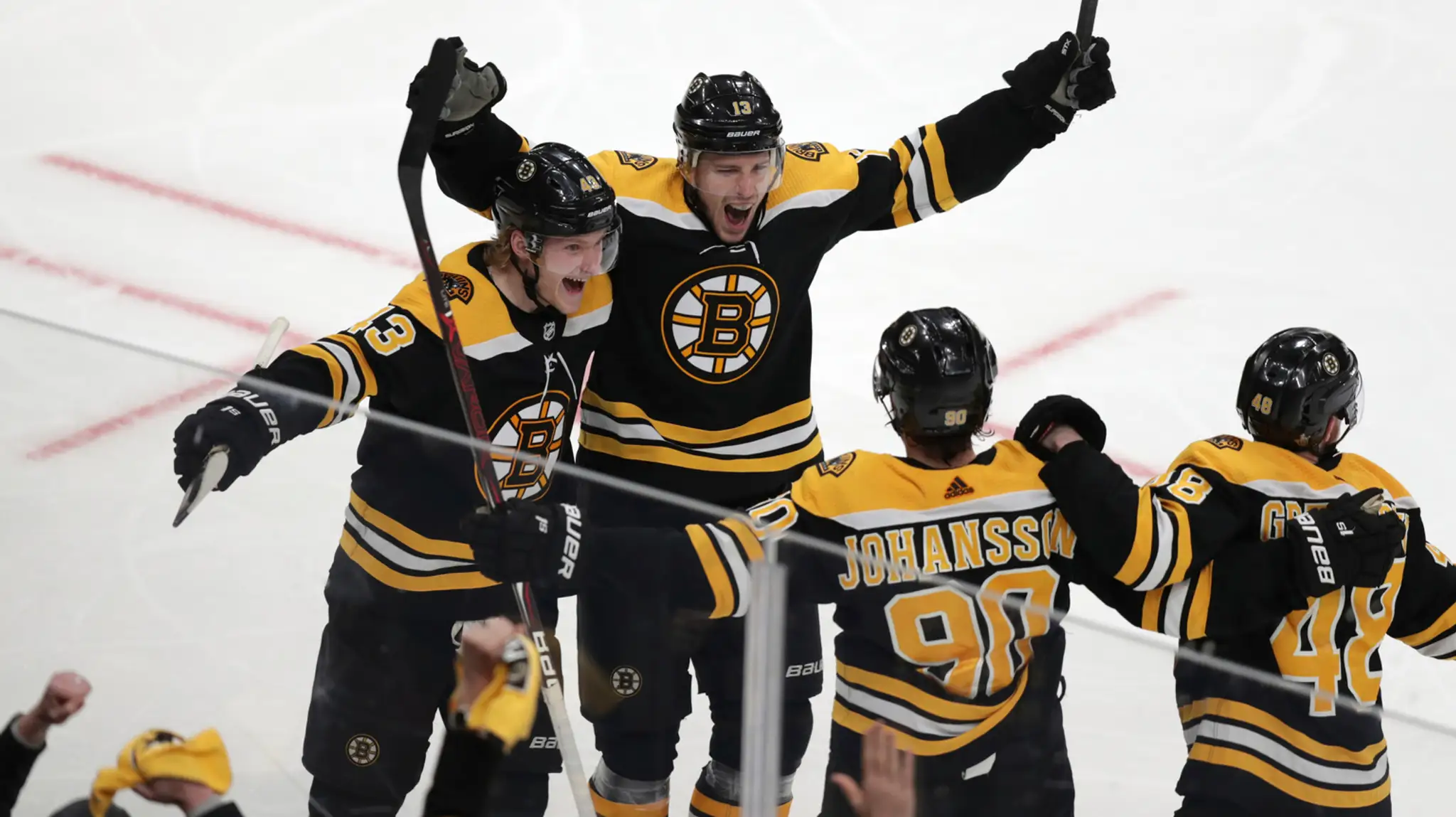 Hokejista Bostonu Charlie Coyle (uprostred) sa teší so spoluhráčmi po strelení víťazného gólu za chrbát brankára Columbusu.