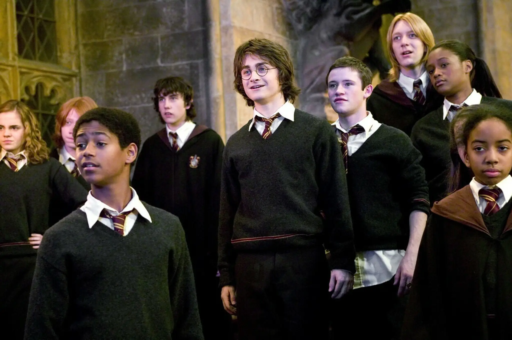 Devon Murray stojac za Danielom Radcliffeom vo filme Harry Potter a Ohnivá čaša