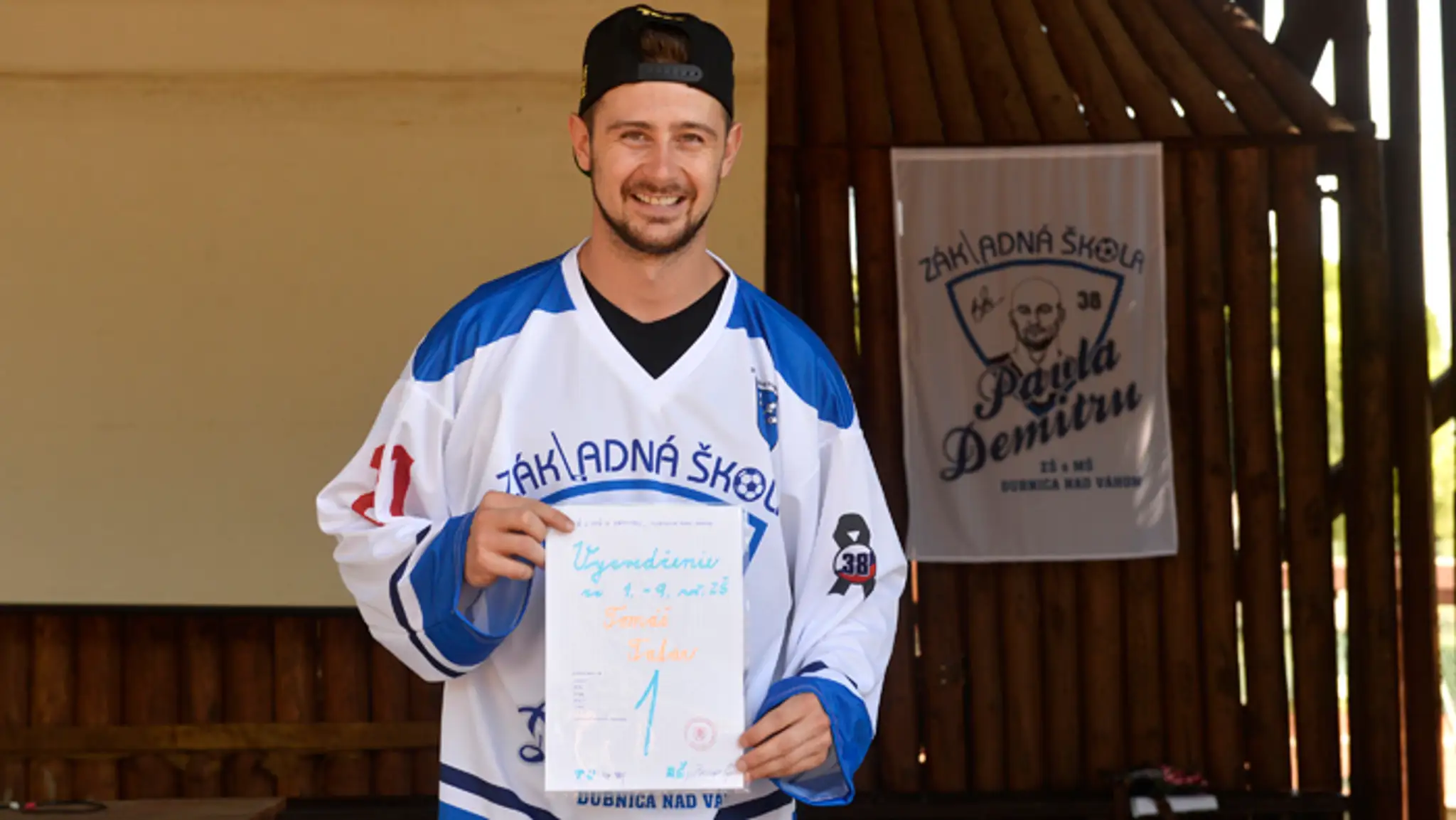 Útočník Detroitu Red Wings Tomáš Tatar pózuje so symbolickým vysvedčením za 1. až 9. ročník.