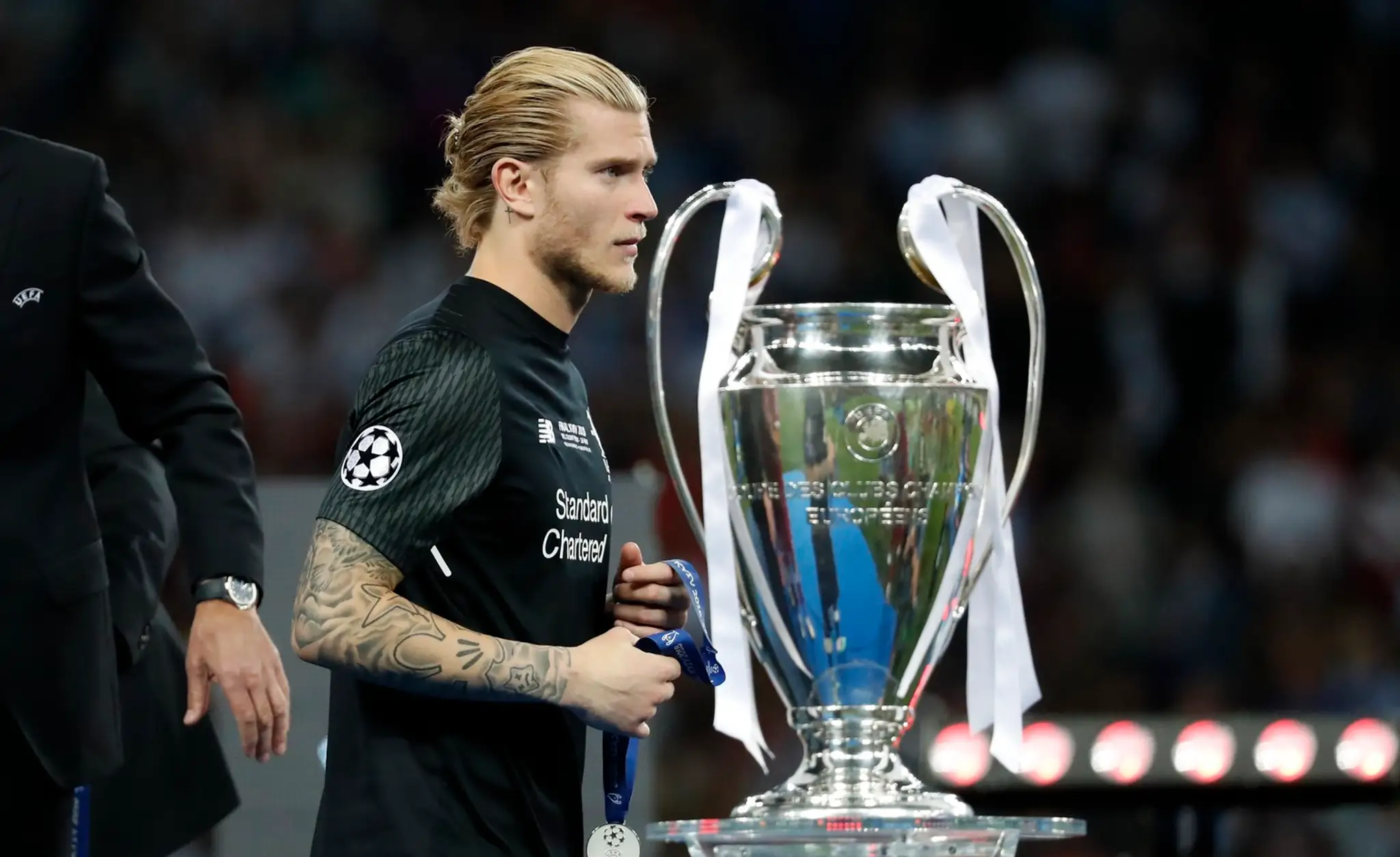 Brankár Liverpoolu Loris Karius kráča pri trofeji pre víťaza Ligy majstrov.