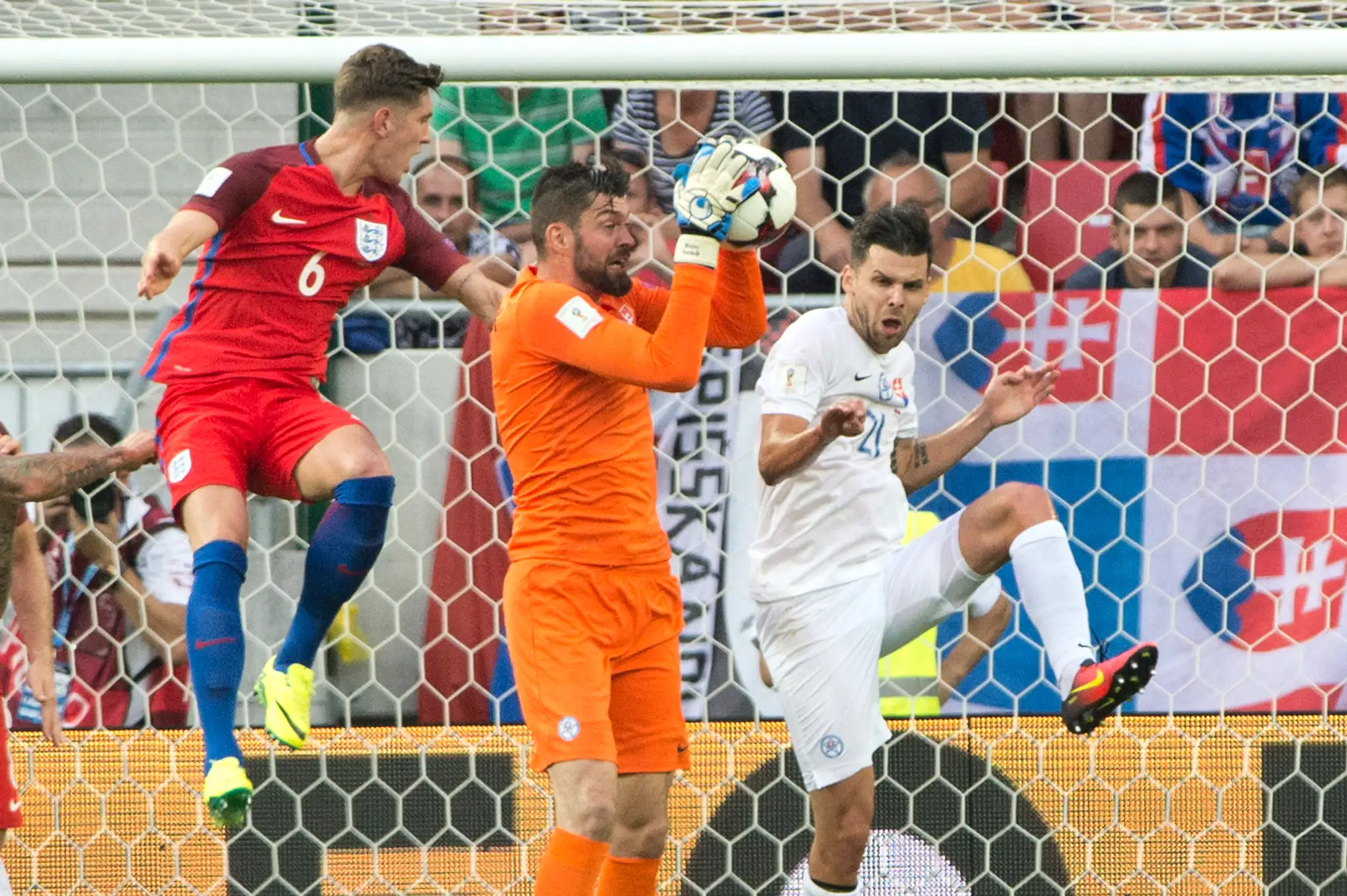 Angličan John Stones (v červenom) v súboji o loptu proti nášmu gólmanovi Matúšovi Kozáčikovi a Michalovi Ďurišovi v kvalifikácii