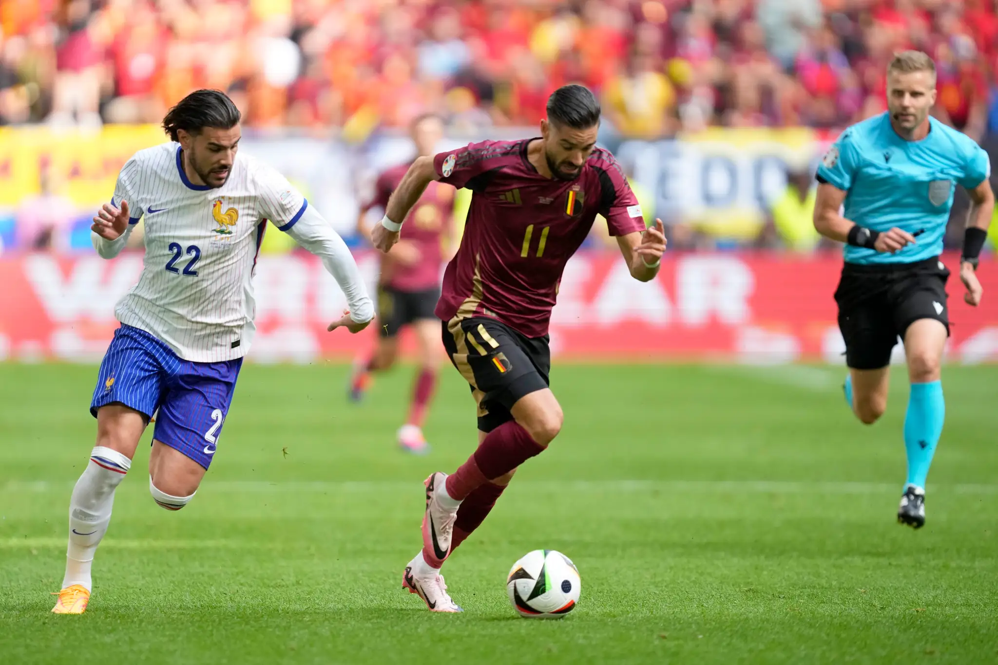 Vľavo Francúz Theo Hernandez uteká za Belgičanom Yannickom Carrascom v osemfinále ME 2024.