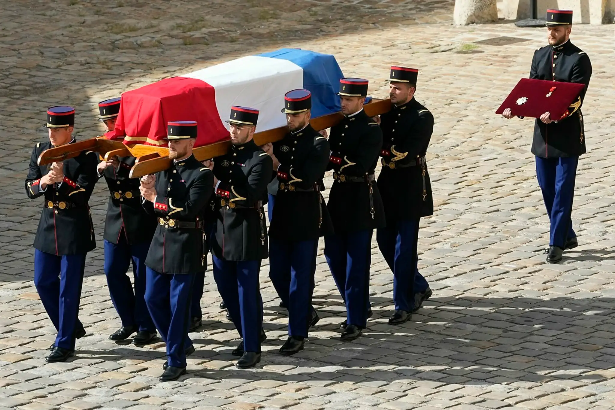 Príslušníci Francúzskej republikánskej gardy nesú rakvu s telom Jeana-Paula Belmonda.