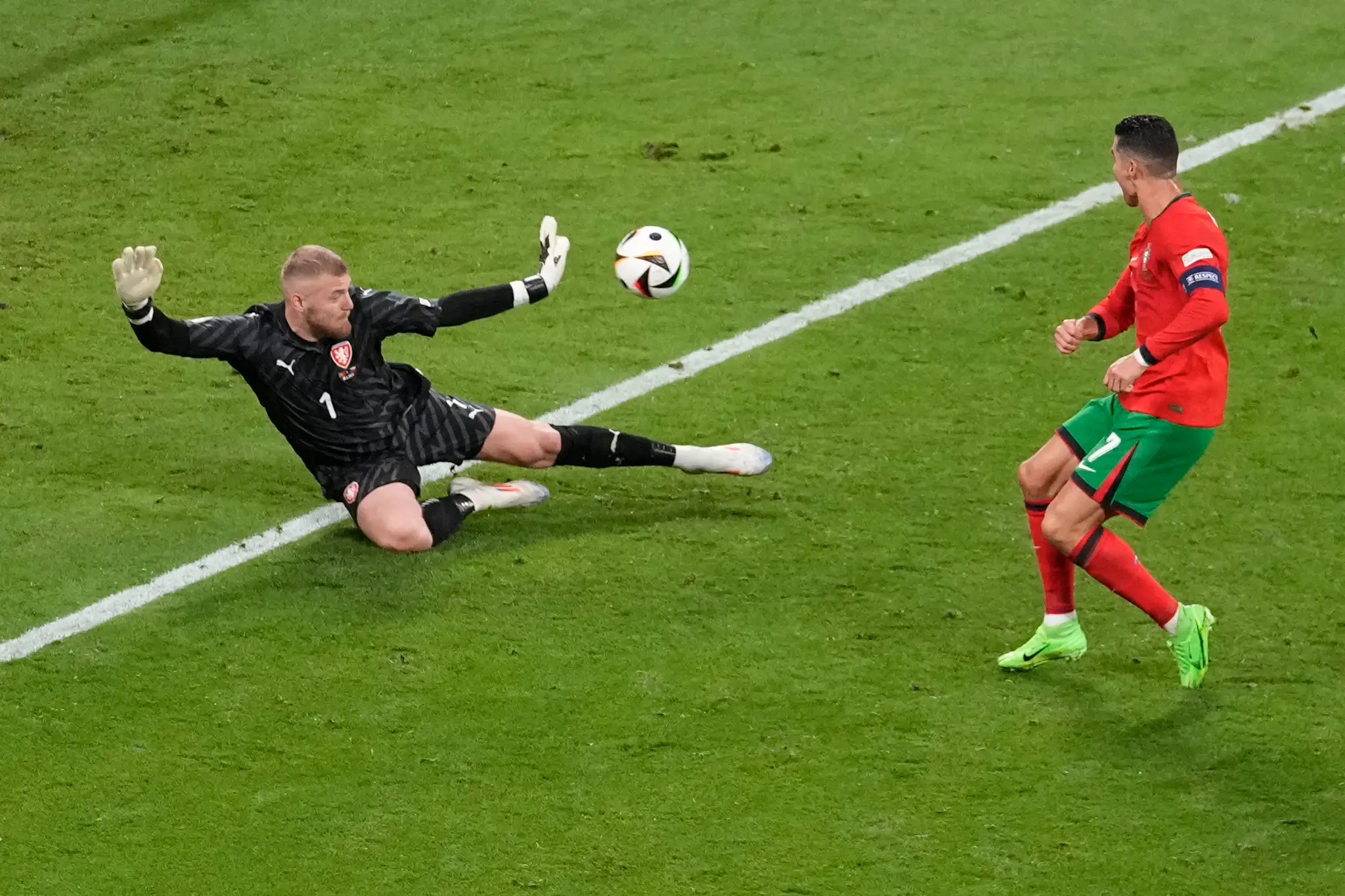 Český brankár Jindřich Staněk (vľavo) zastavuje strelu Portugalca Cristiana Ronalda.
