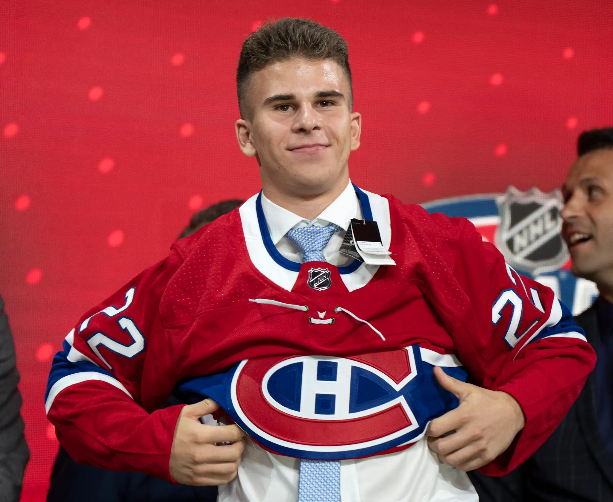 Filip Mešár pózuje s dresom Montrealu na drafte NHL 2022.