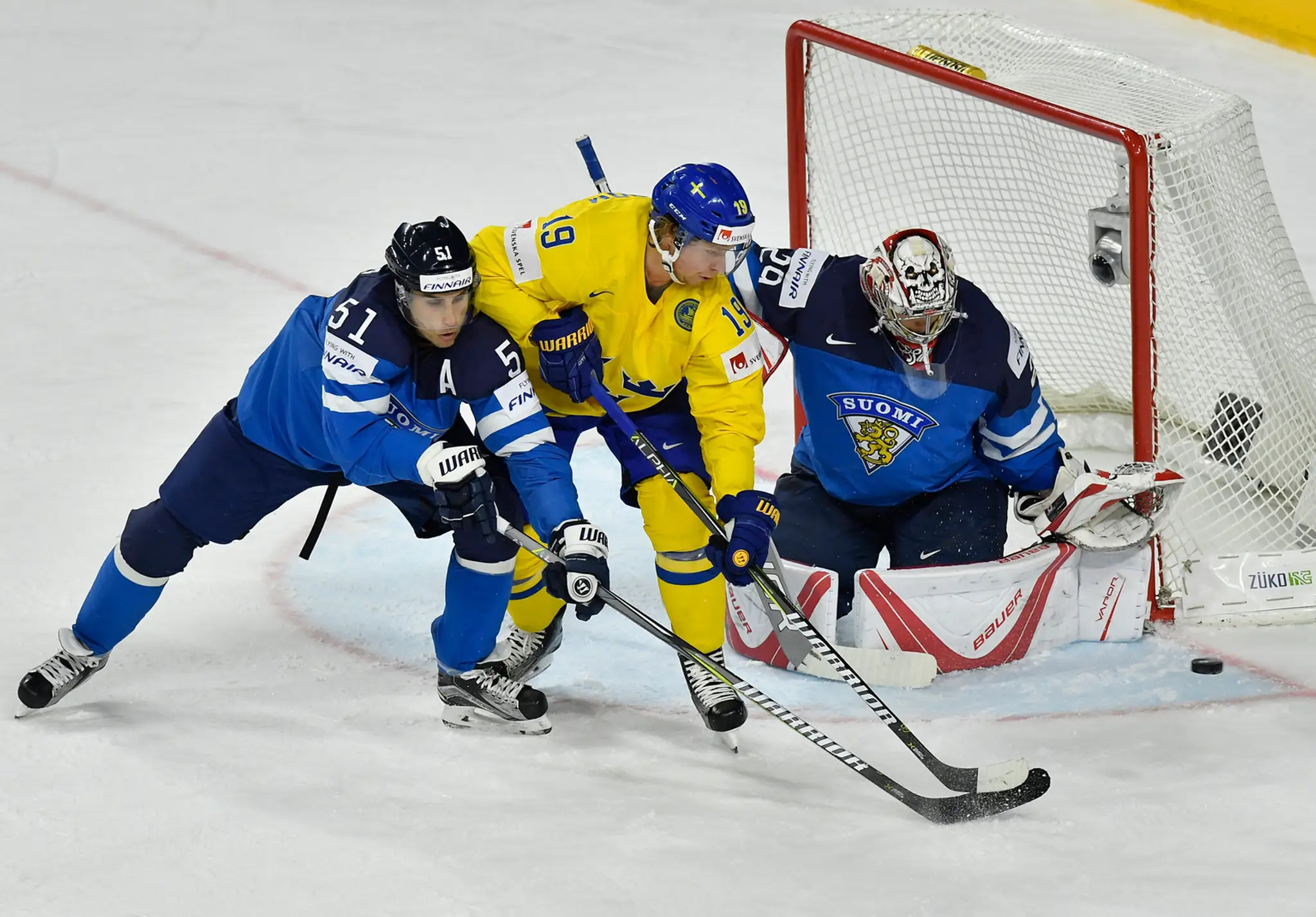 Nicklas Bäckström (v strede) zo Švédska sa snaží v semifinále MS 2017 prekonať fínskeho gólmana Harriho Säteriho (vpravo), ataku