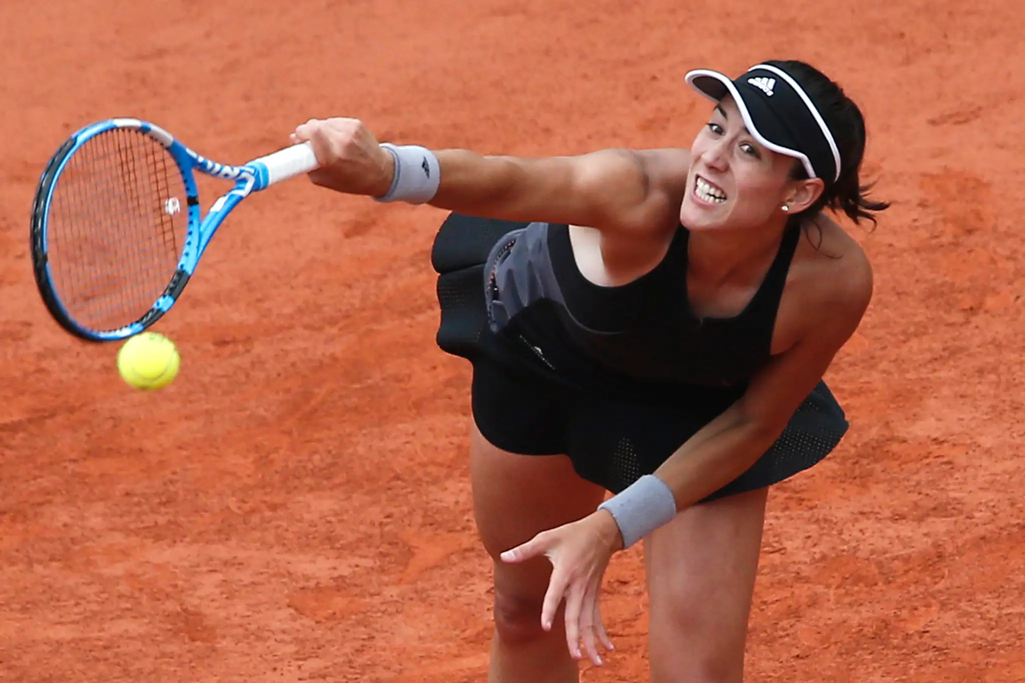 Garbine Muguruzová podáva vo štvrťfinále dvojhry proti Marii Šarapovovej na grandslamovom turnaji Roland Garros.