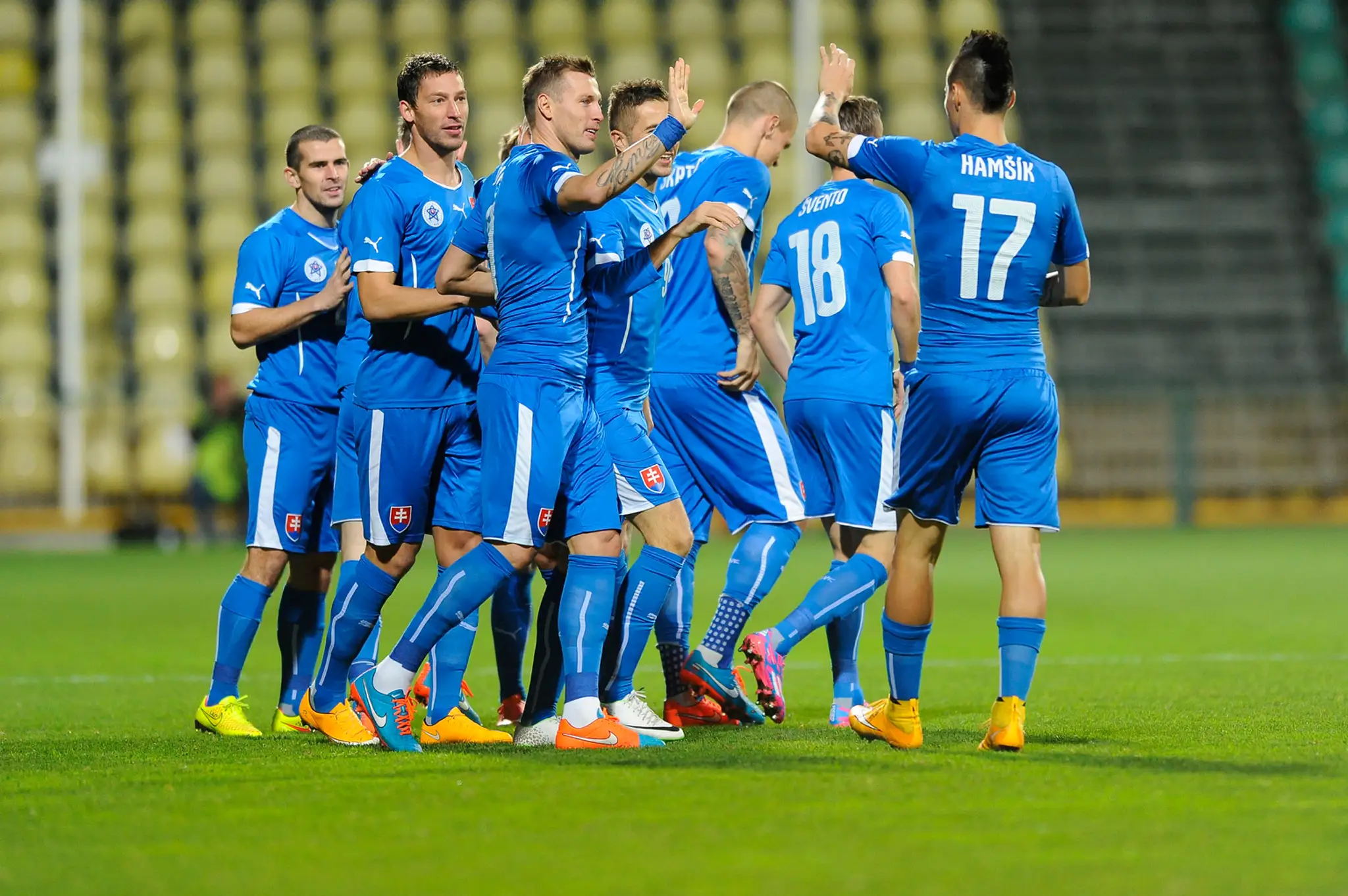 Slovenskí futbalisti oslavujú Hološkou gól do siete Fínska.