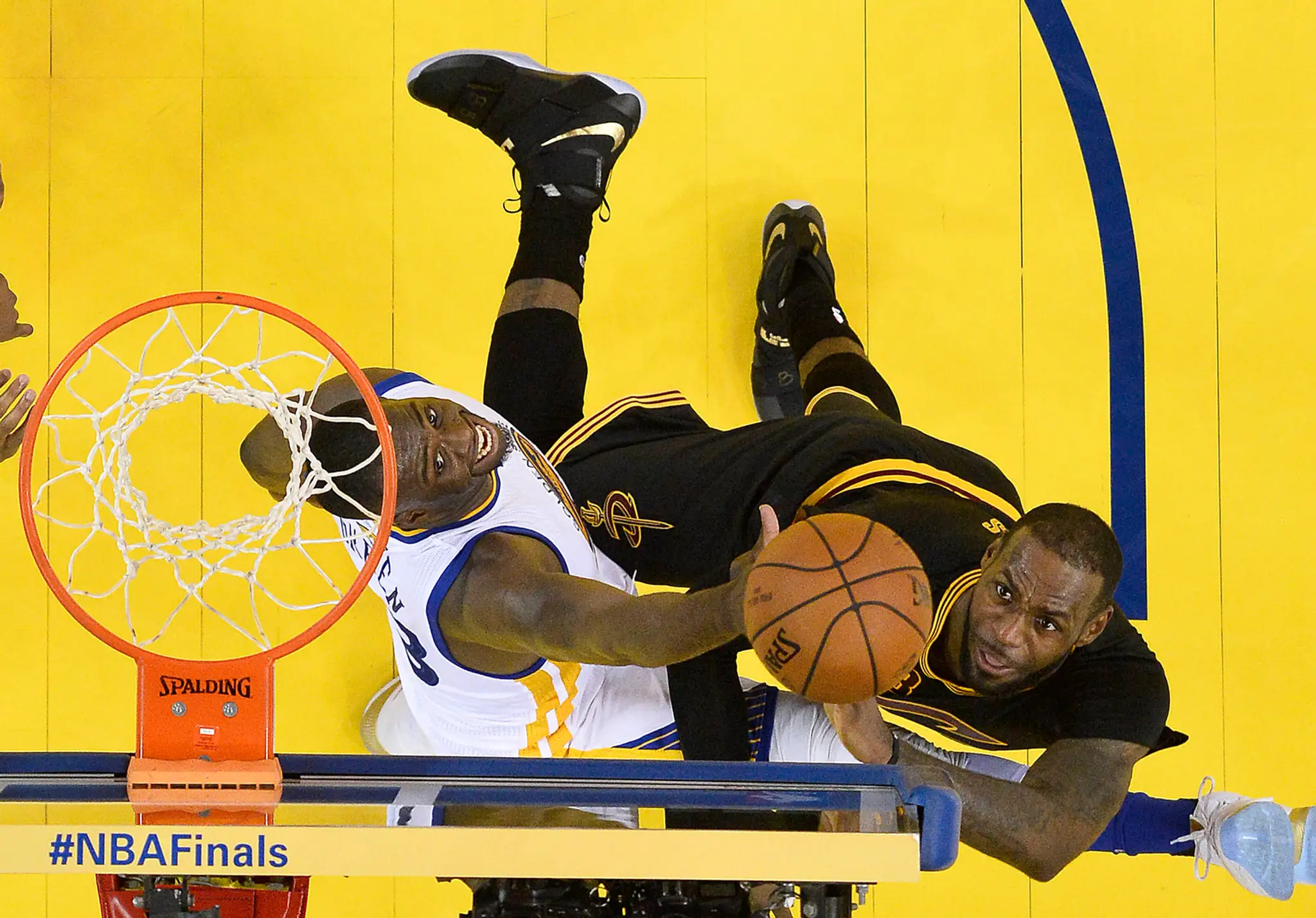 Draymond Green bojuje pod košom s LeBronom Jamesom.
