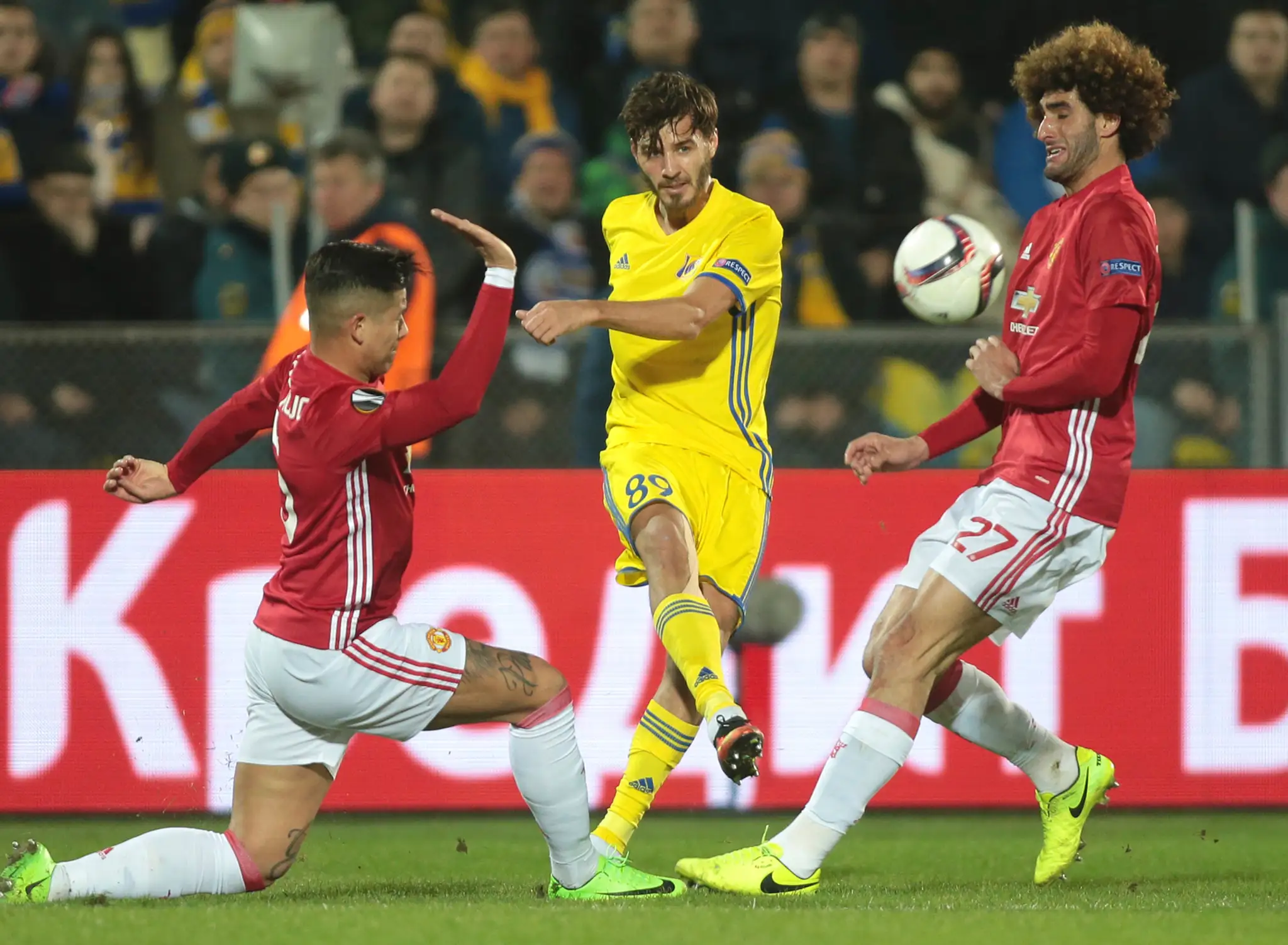 Aleksandr Erochin (v strede) z Rostova v obkľúčení Marca Roja (vľavo) a Marouana Fellainiho z ManUtd v osemfinále EL.