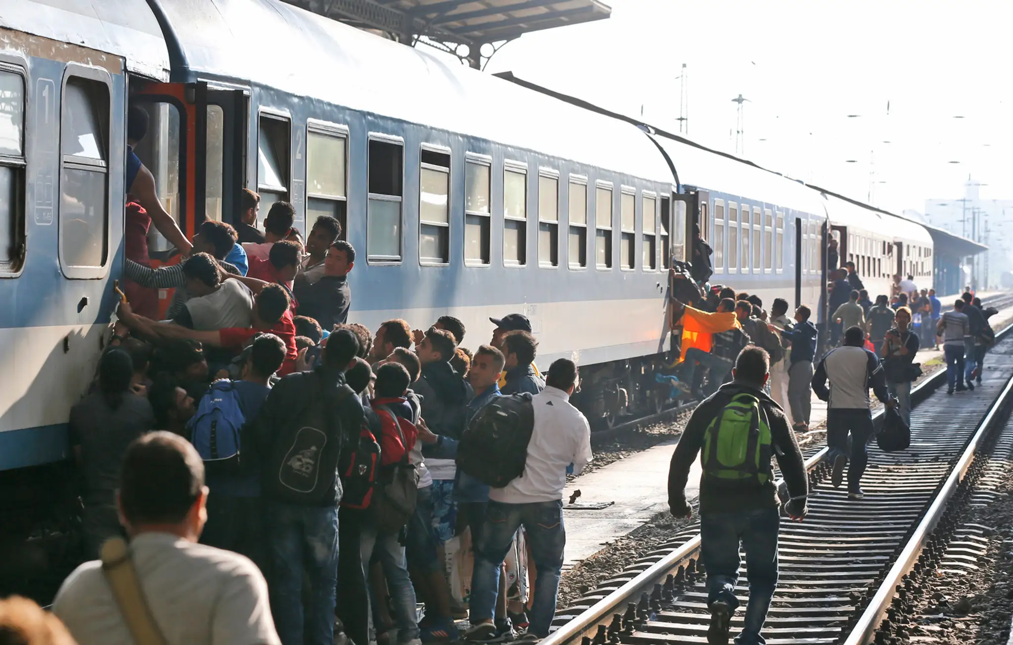 Migranti sa snažia nastúpiť do vlaku v Budapešti.