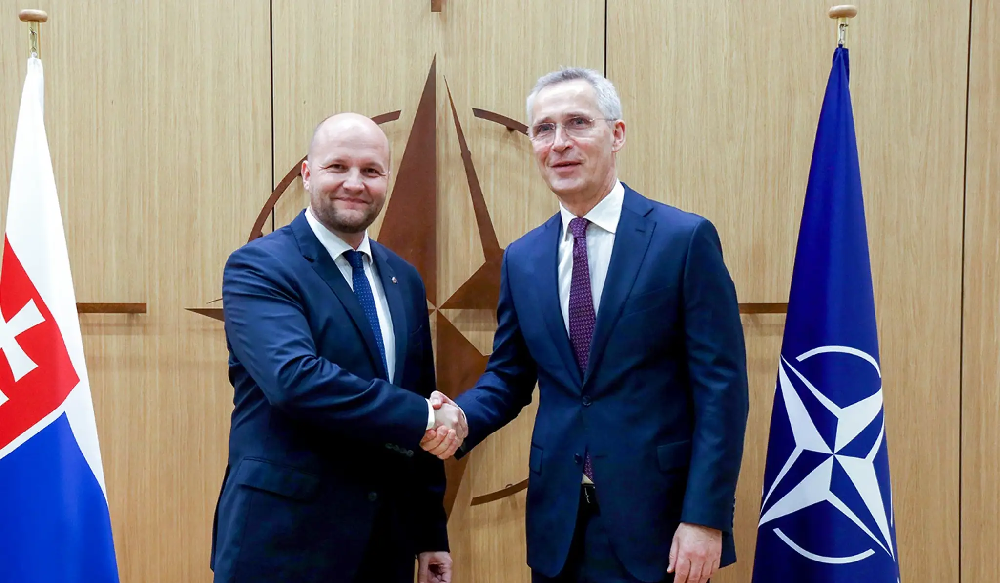 Dočasne poverený minister obrany SR Jaroslav Naď  (vľavo) a generálny tajomník NATO Jens Stoltenberg pózujú počas stretnutia v Bruseli.