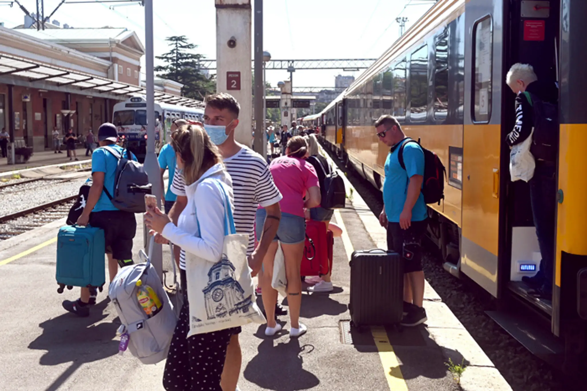 Turisti vystupujú z vlaku súkromného dopravcu na stanici v chorvátskom meste Rijeka. (1. júla 2020)