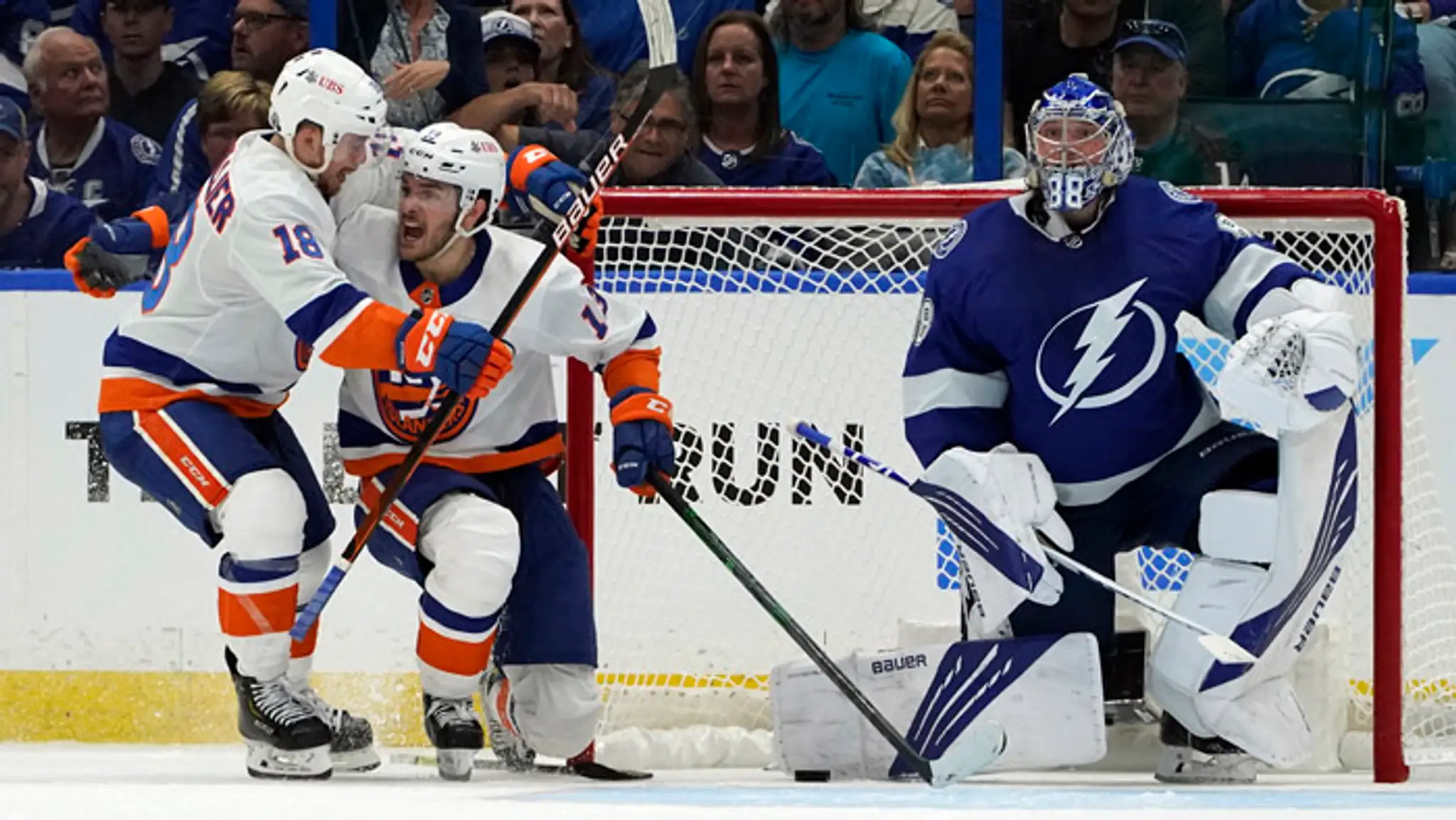 Hokejista New Yorku Islanders  Mathew Barzal (uprostred) sa teší po strelení gólu.