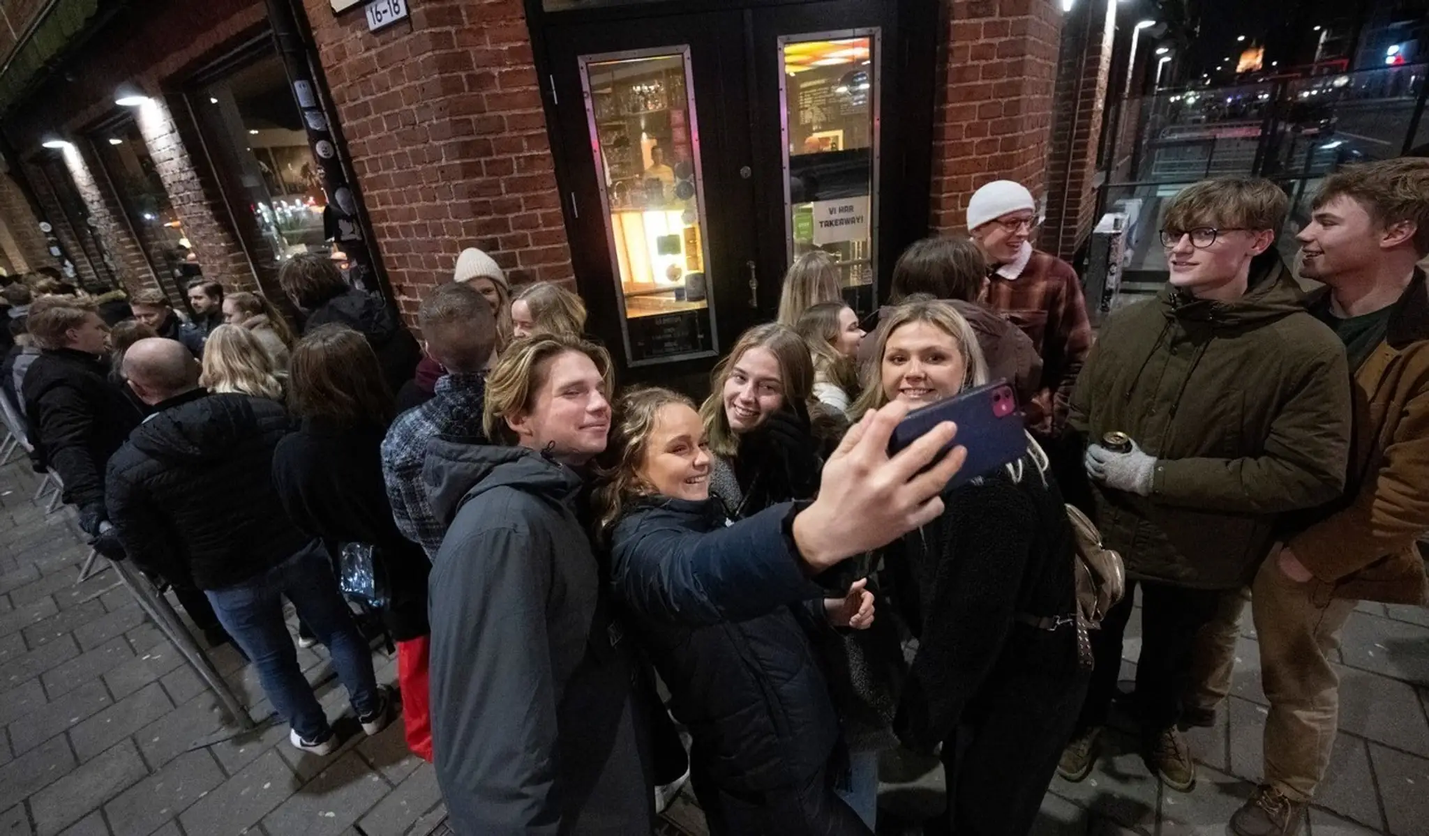 Ľudia stoja v rade pred nočným klubom KB v centre Malmö..jpg