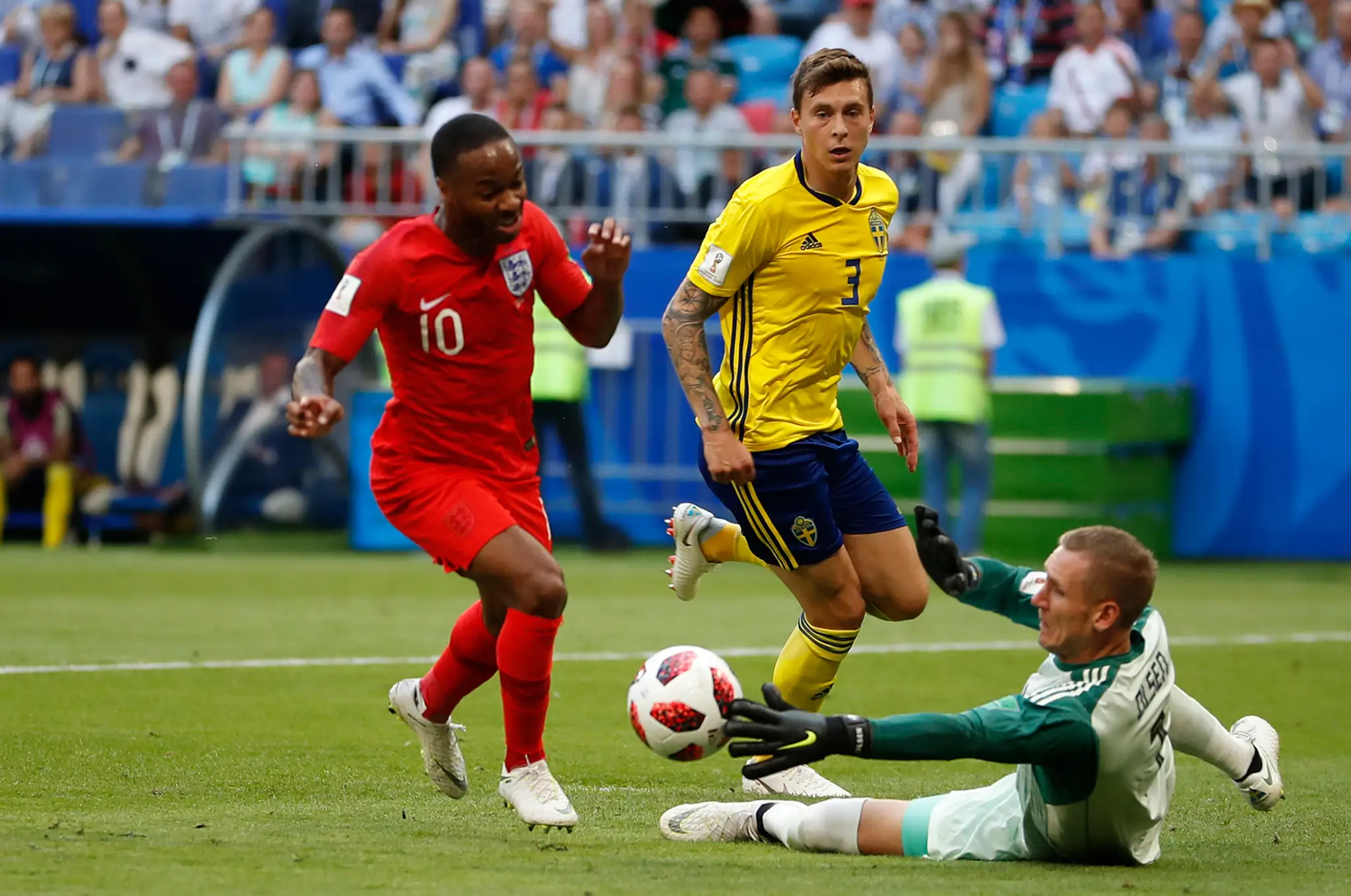 Angličan Raheem Sterling (vľavo) sa snaží obísť švédskeho brankára Robina Olsena vo štvrťfinále MS 2018.
