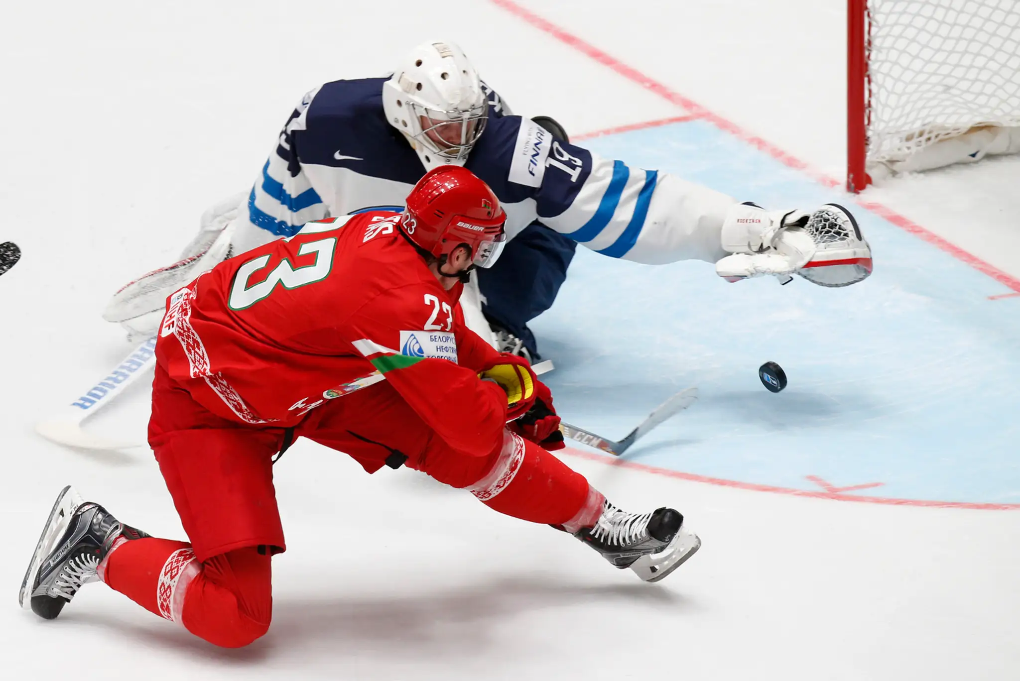 Bielorus Andrej Stas pred gólmanom Fínska Mikkom Koskinenom počas duelu B-skupiny MS v Rusku.
