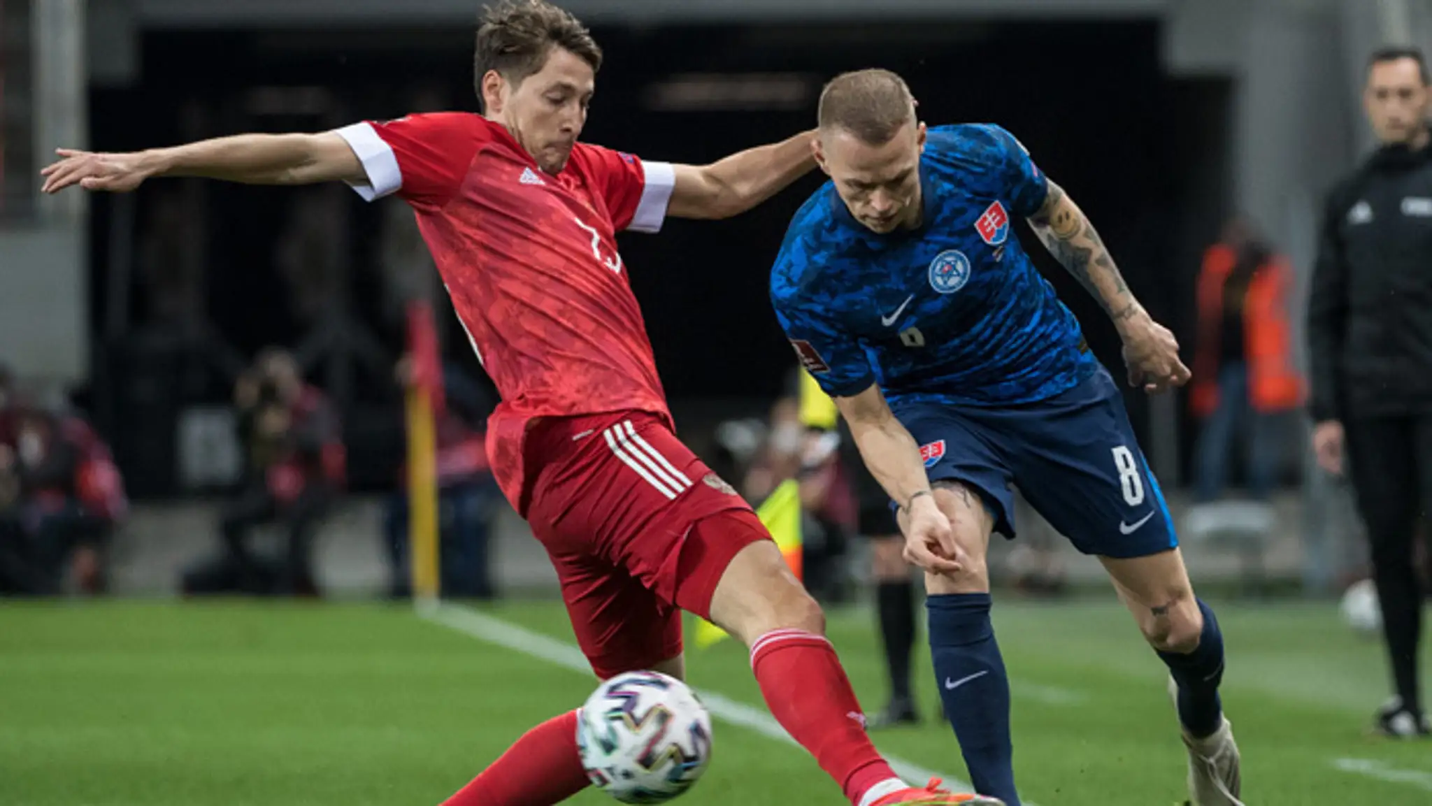 Ruský futbalista Darev Kuzjajev (vľavo) a Ondrej Duda bojujú o loptu v kvalifikačnom zápase H-skupiny.