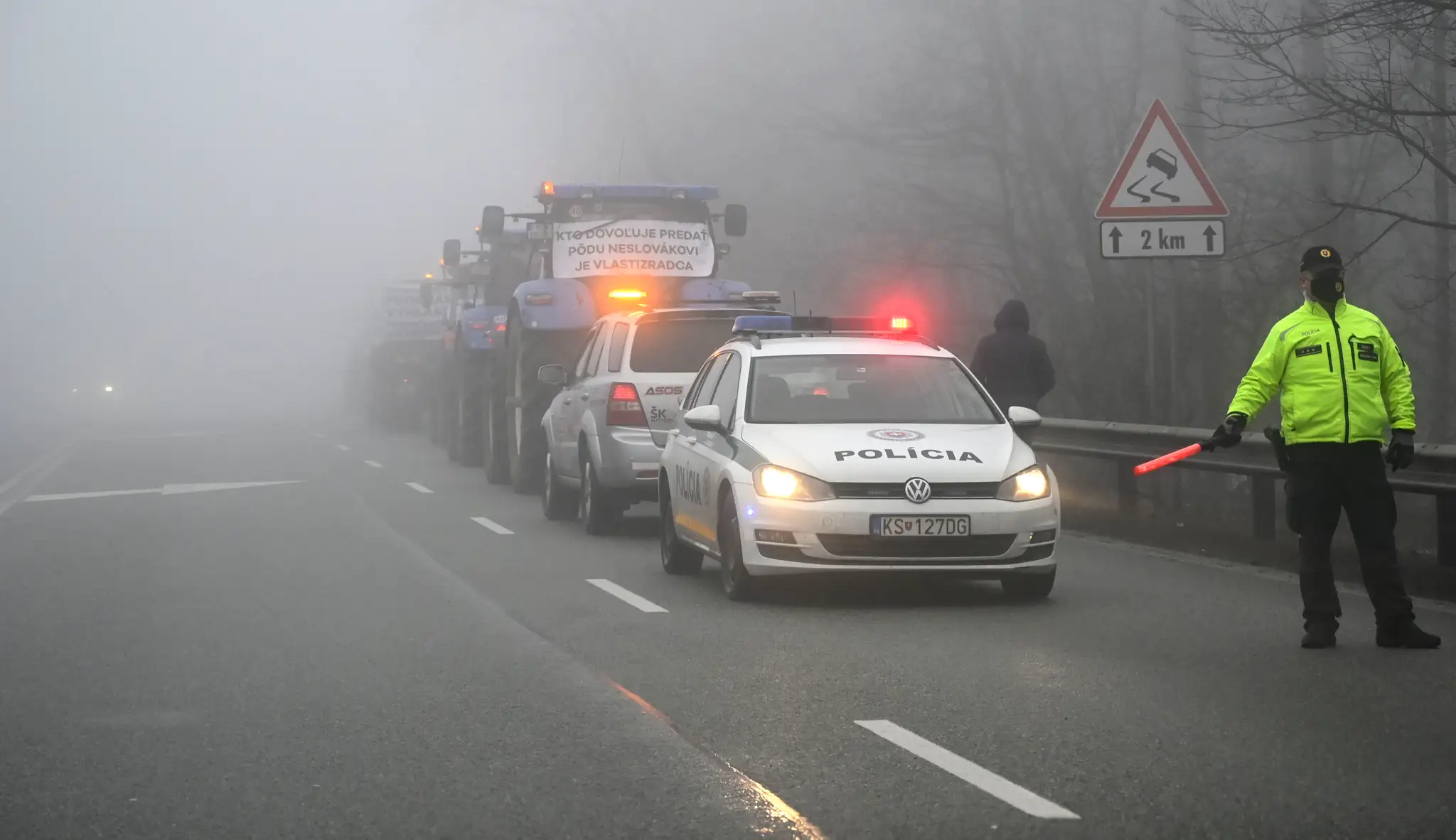 Policajt riadi premávku počas blokovania horského priechodu Dargov farmármi.