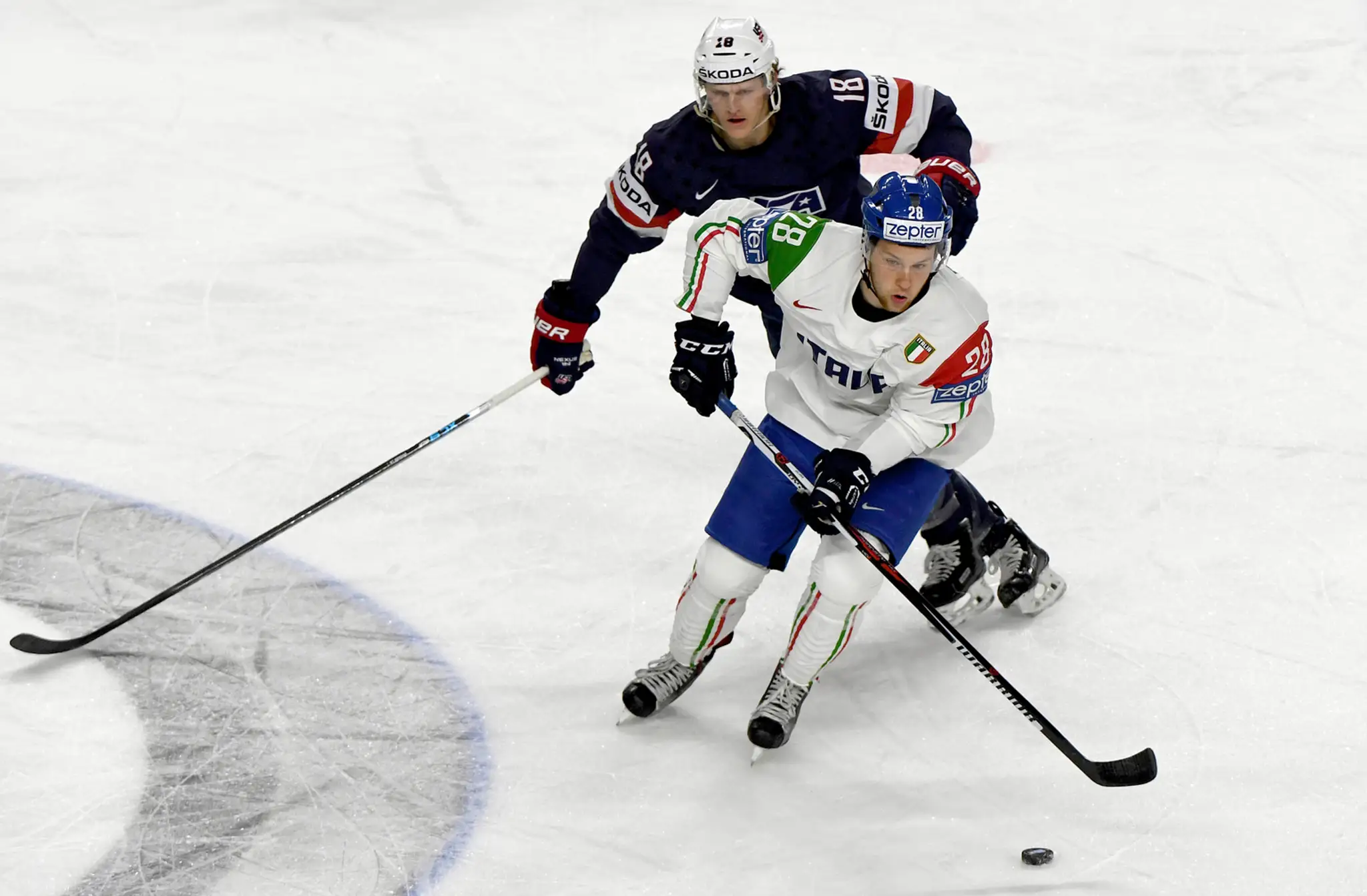 Američan Christian Dvorak (vzadu) naháňa v zápase MS 2017 Taliana Daniela Gliru.