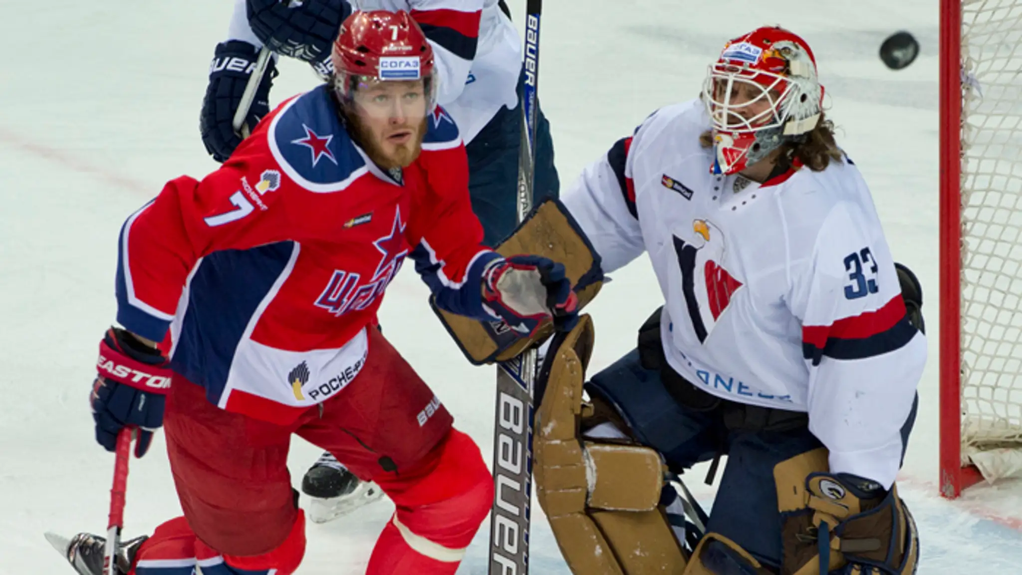 Brankár Slovana Barry Brust a vľavo Geoff Platt (CSKA) počas druhého stretnutia 1. kola play off KHL.