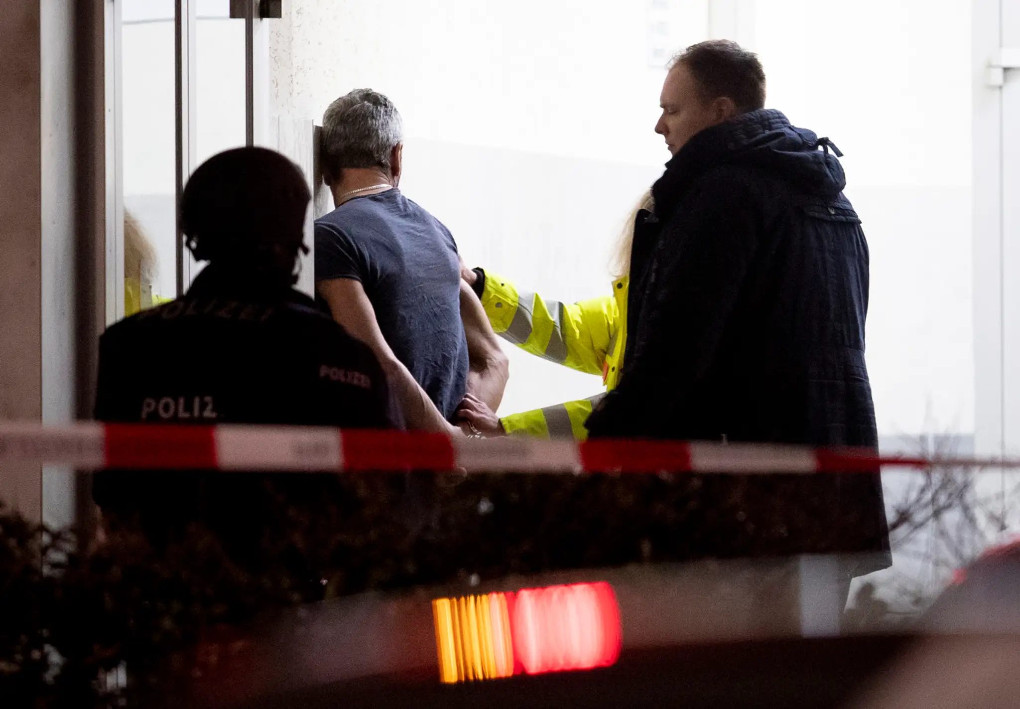Policajní experti kontrolujú poškodené auto po streľbe v nemeckom Hanau.