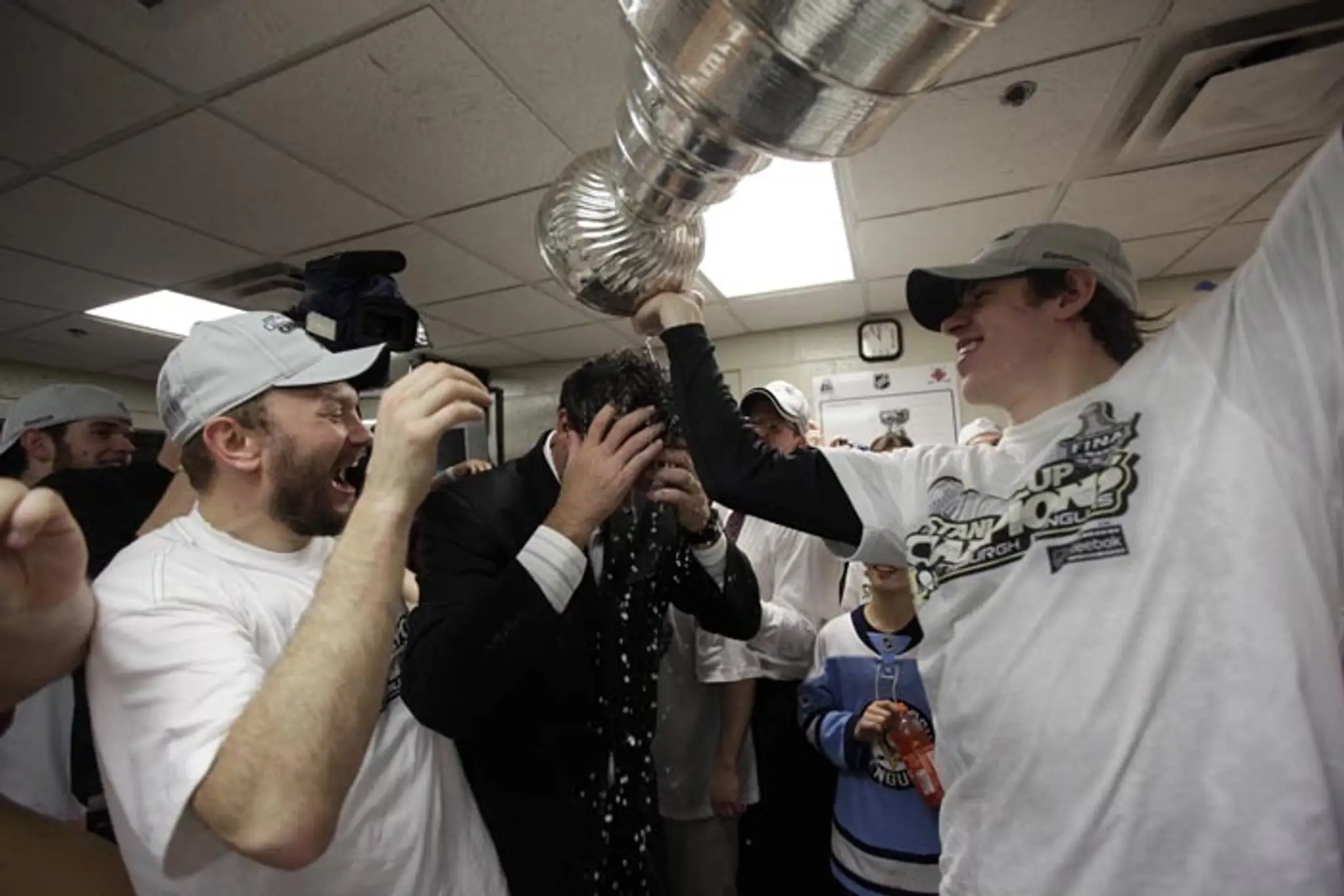 Jevgenij Malkin (vpravo) leje šampanské na spoluvlastníka Penguins Maria Lemieuxa po zisku Stanleyho pohára (12. júna 2009).