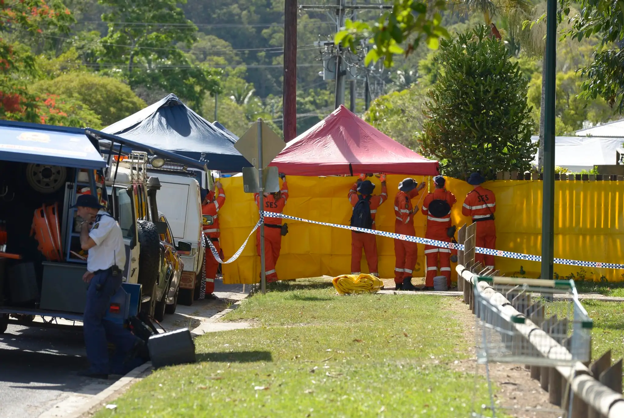 Záchranári dávajú pásku pred plot domu v austrálskom meste Cairns v štáte Queensland, kde polícia objavila osem mŕtvych detí a z