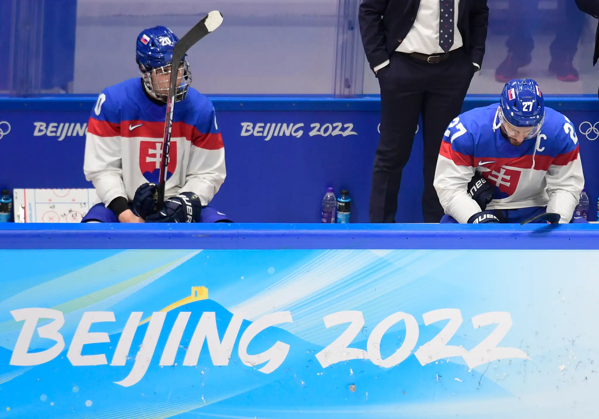 Zľava smutní Juraj Slafkovský a kapitán Marek Hrivík po semifinále s Fínskom na ZOH 2022.